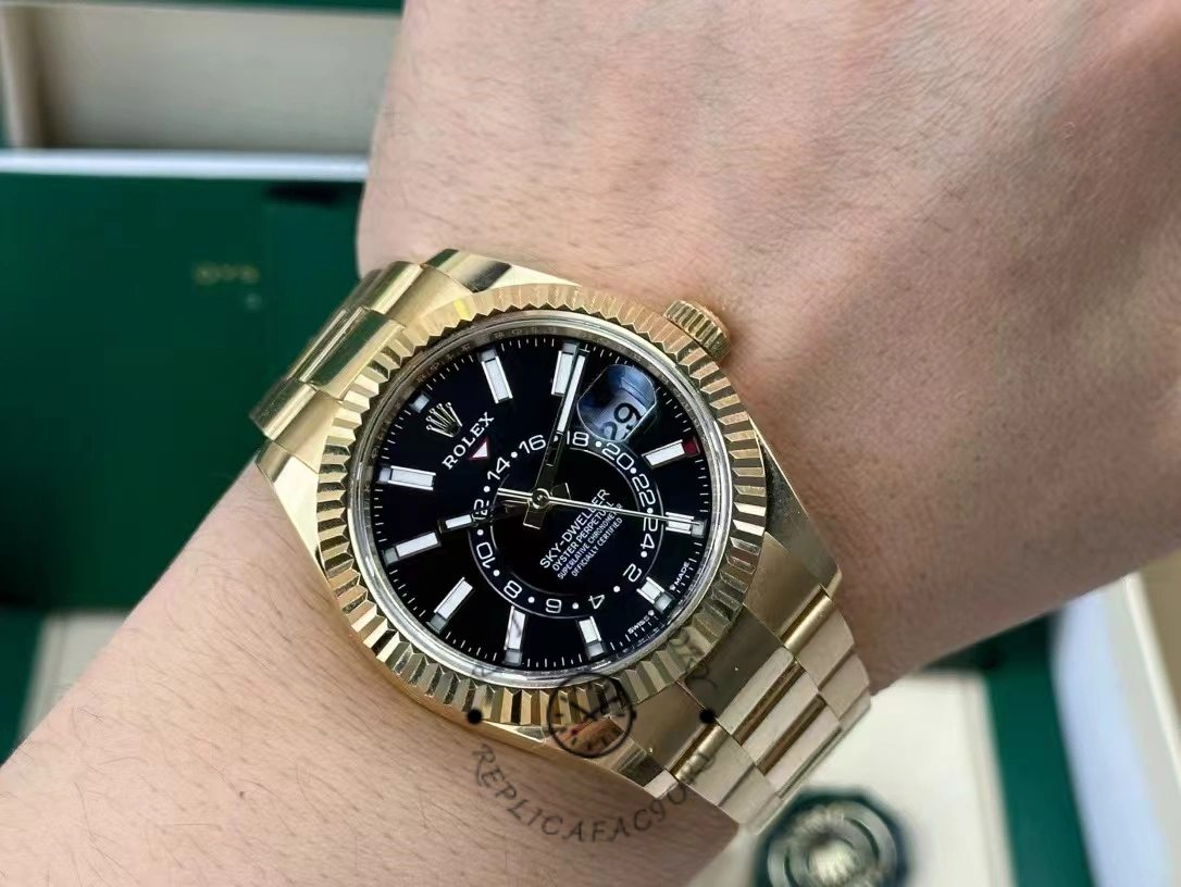 Rolex Sky-Dweller M336938-0002, on-wrist shot showing gold bracelet and black dial.
