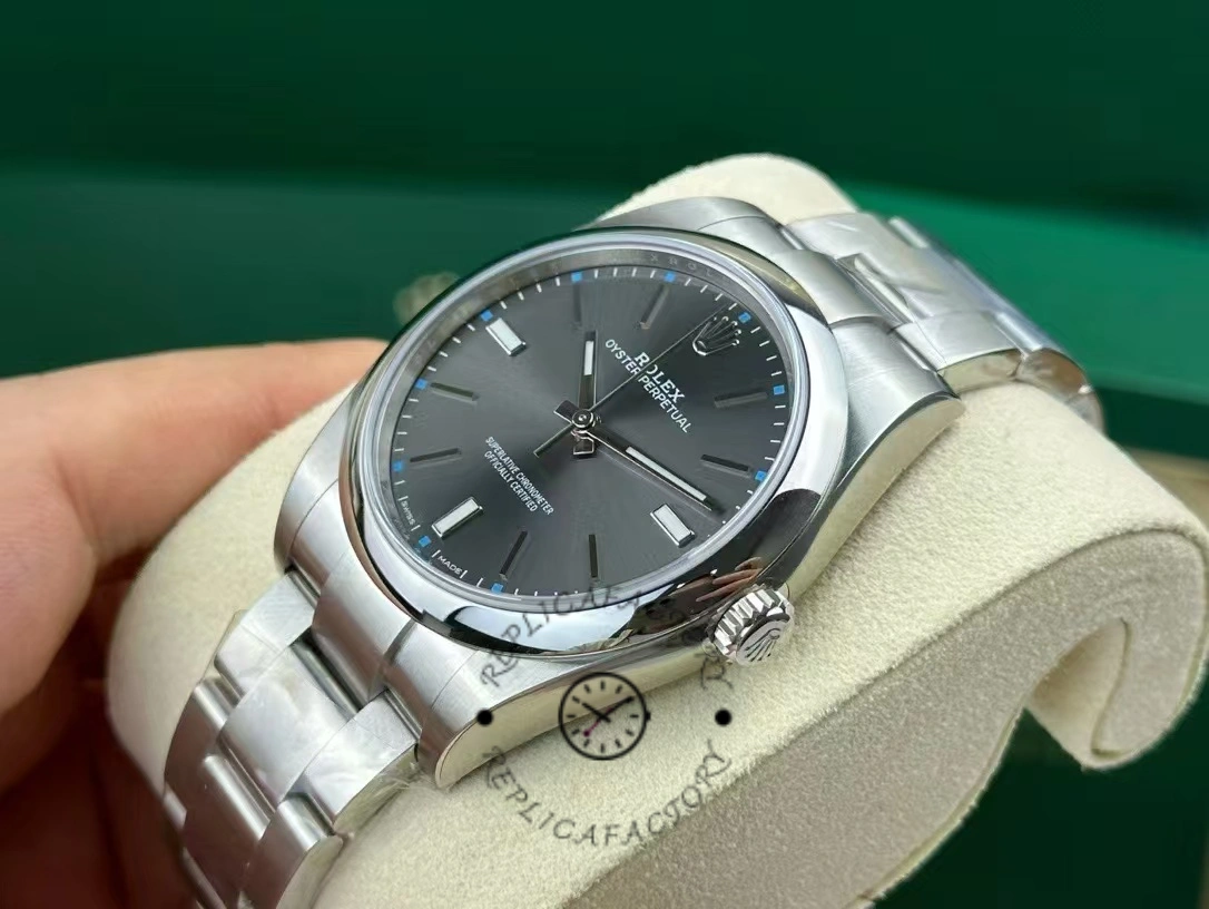 Angled view of the Rolex Oyster Perpetual 114300 0001 on cushion showing case profile and dial.