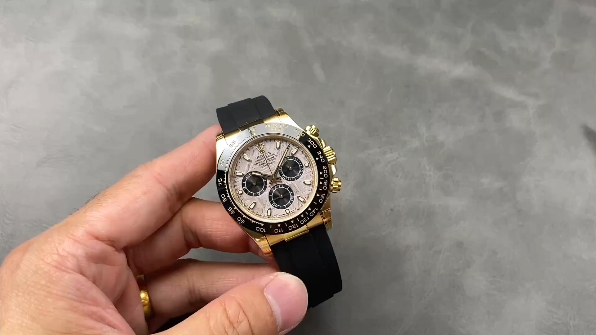 Rolex Daytona 126518LN 0016, video image showing the watch held in hand on black Oysterflex strap. - Video