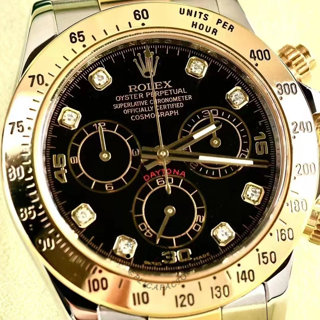 Rolex Daytona 116523 dial close-up, black diamond markers and gold tachymeter bezel.