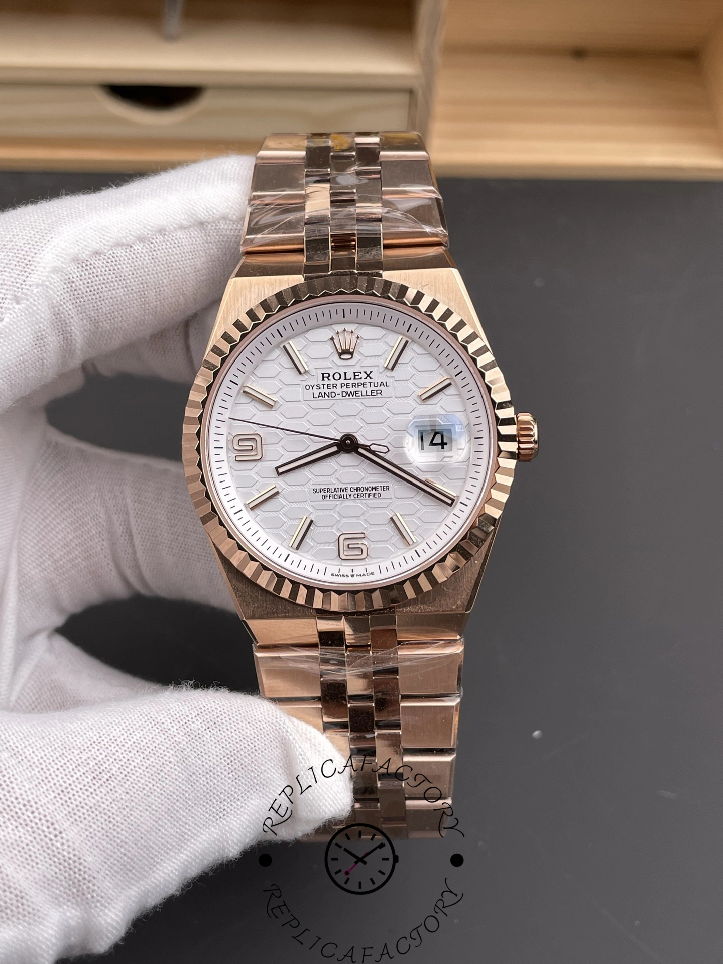 Handheld front angle of Rolex Land-Dweller M127235-0001 Replica showing fluted bezel and white dial details.
