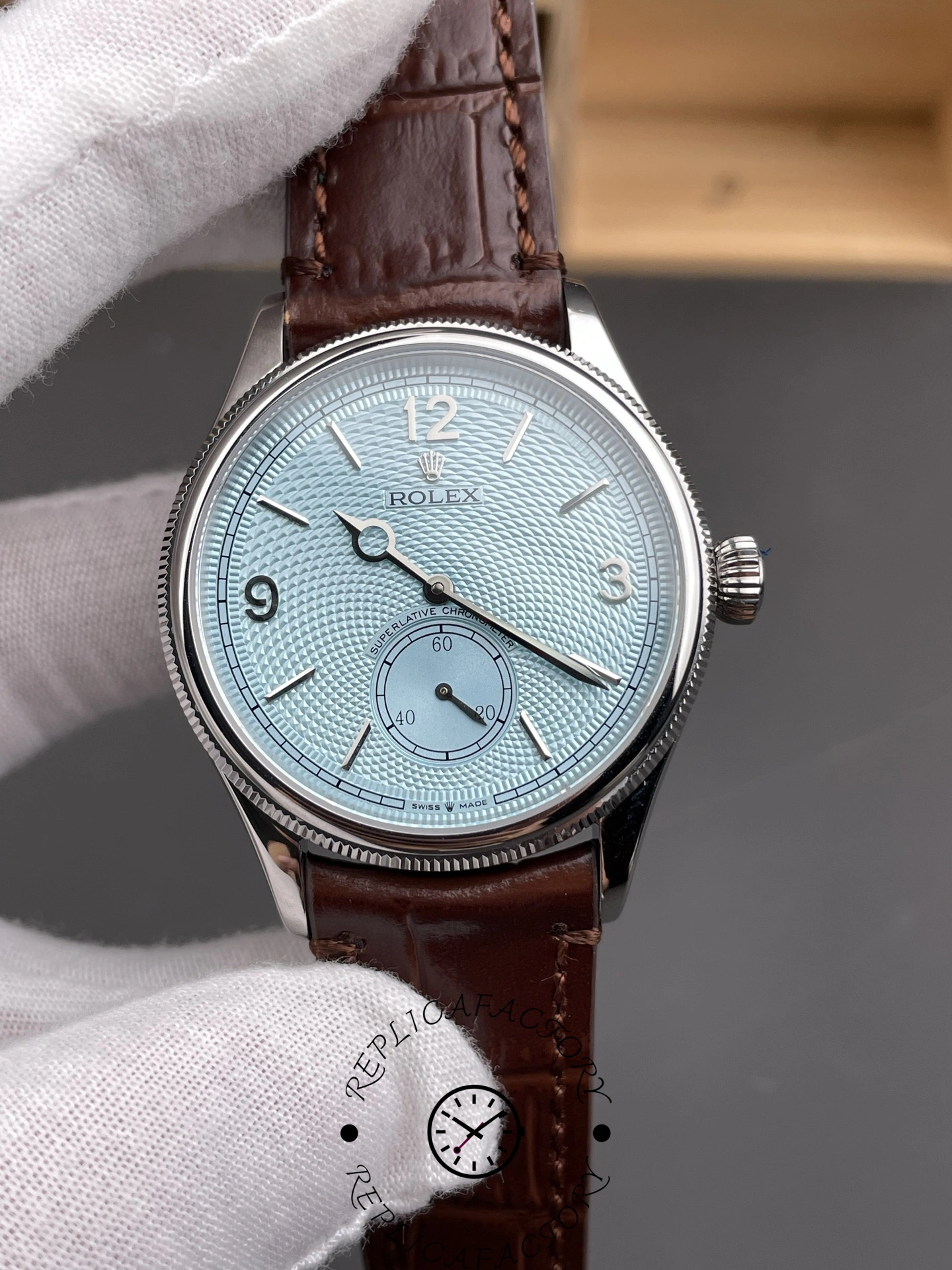 Hand-held view of the Rolex 1908 52506-0002 showing the ice blue dial and polished case.