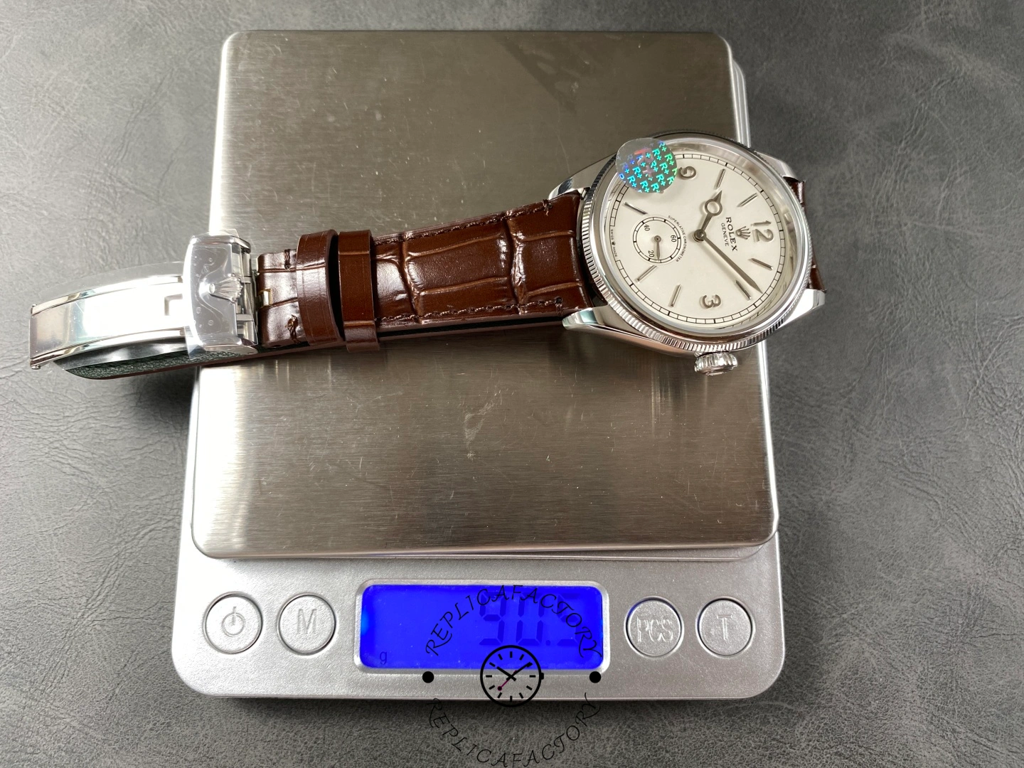 Weight measurement of Rolex 1908 52509-0006 39mm replica displayed on a digital scale.
