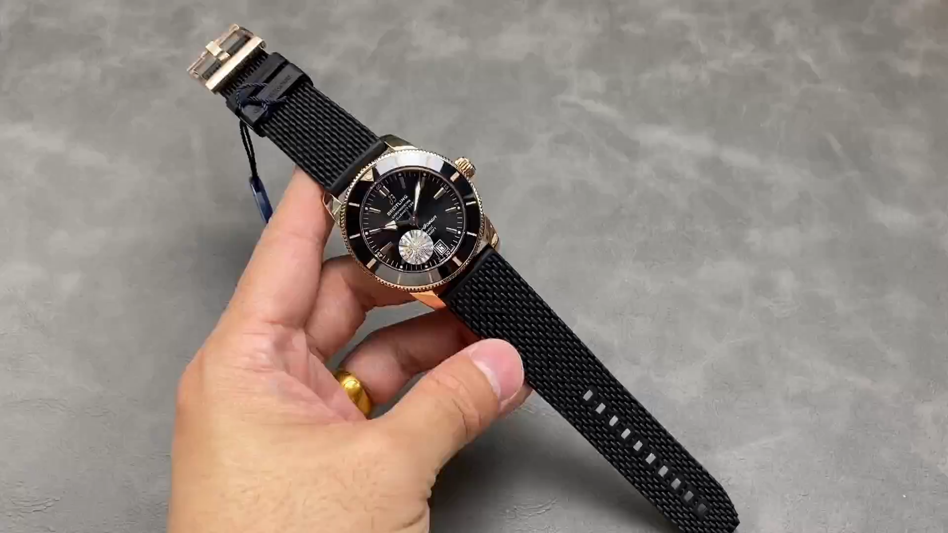 Breitling RB2010121B1S1, strap display in hand showing dial, black mesh strap length and fit.