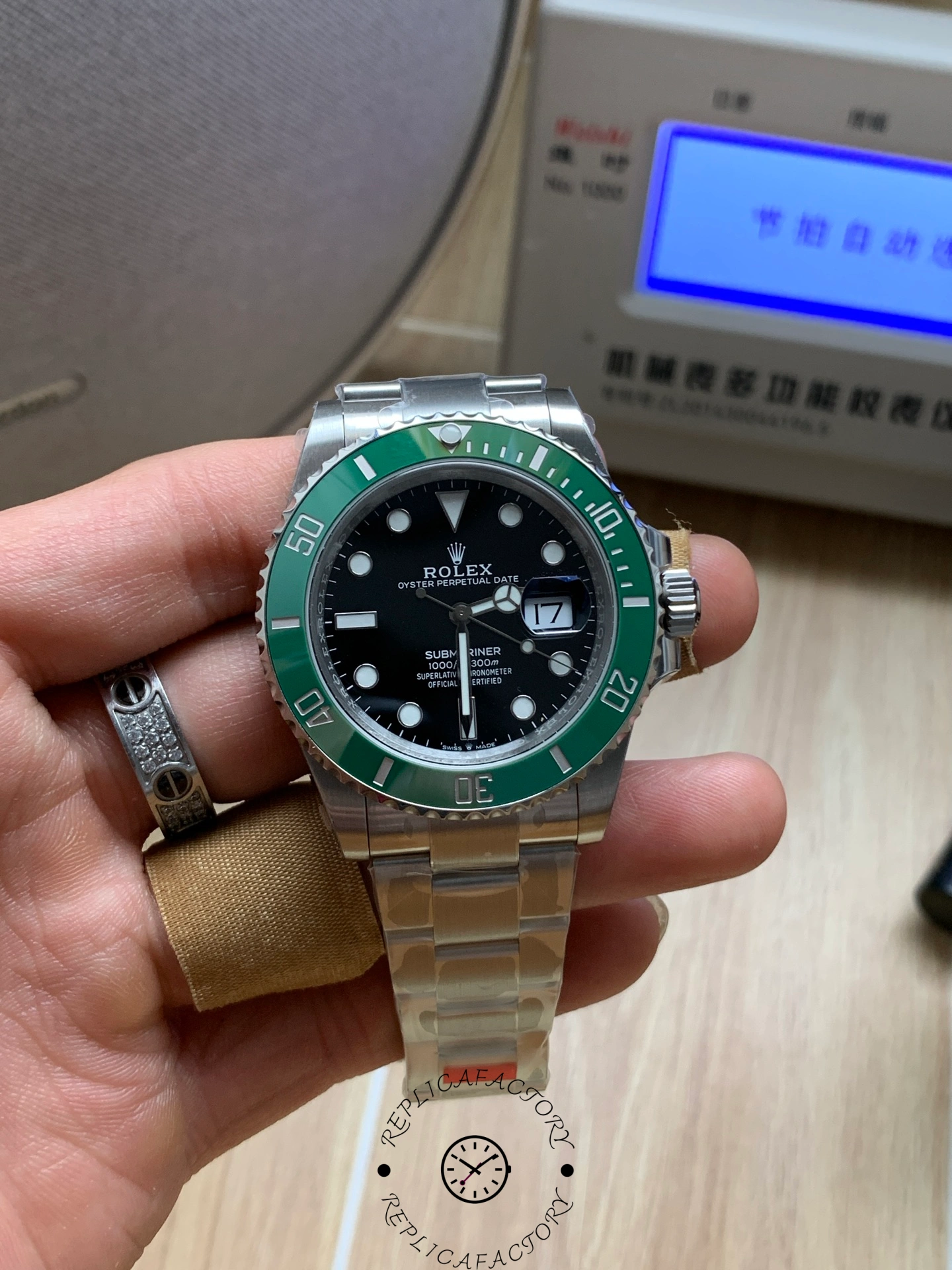Rolex Submariner 126610LV, hand-held full view with green bezel and cyclops date.