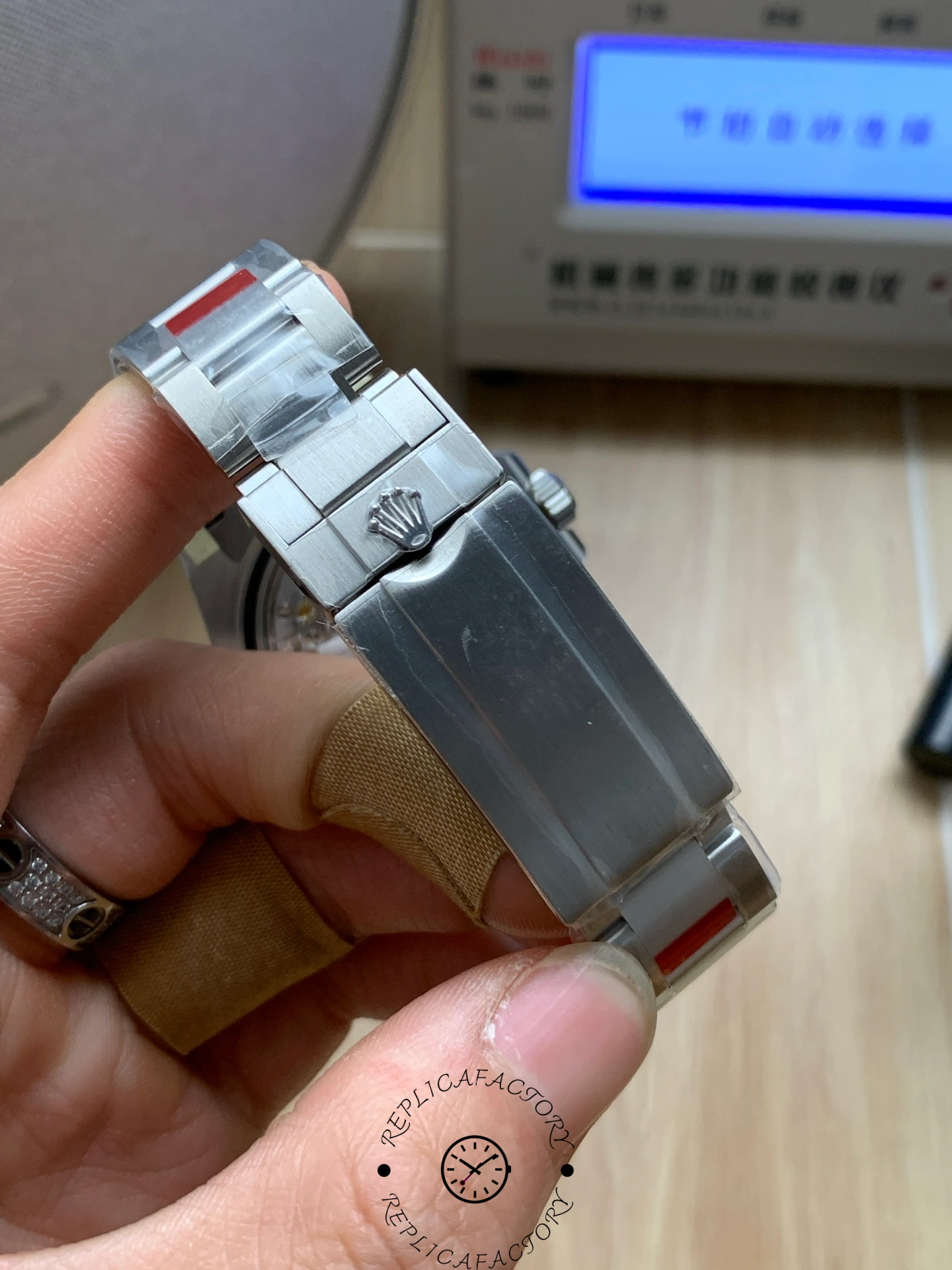 Rolex Submariner 126610LV, clasp and bracelet wrapped with protective tape, close view.