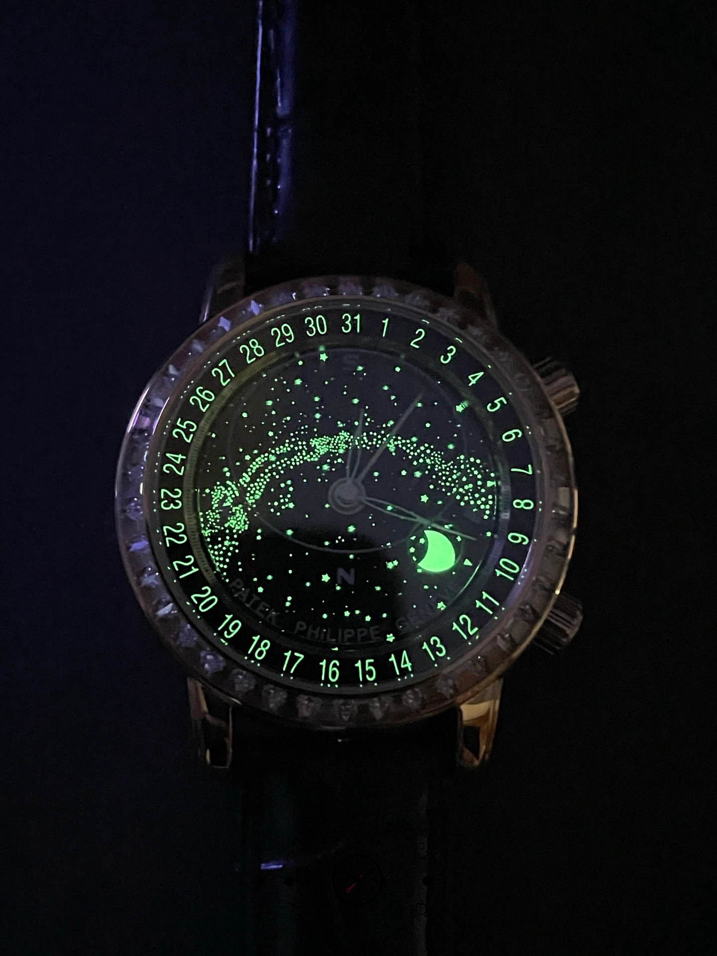 Lume shot of Patek Philippe 6104R 001 showing glowing markers on the black celestial dial.