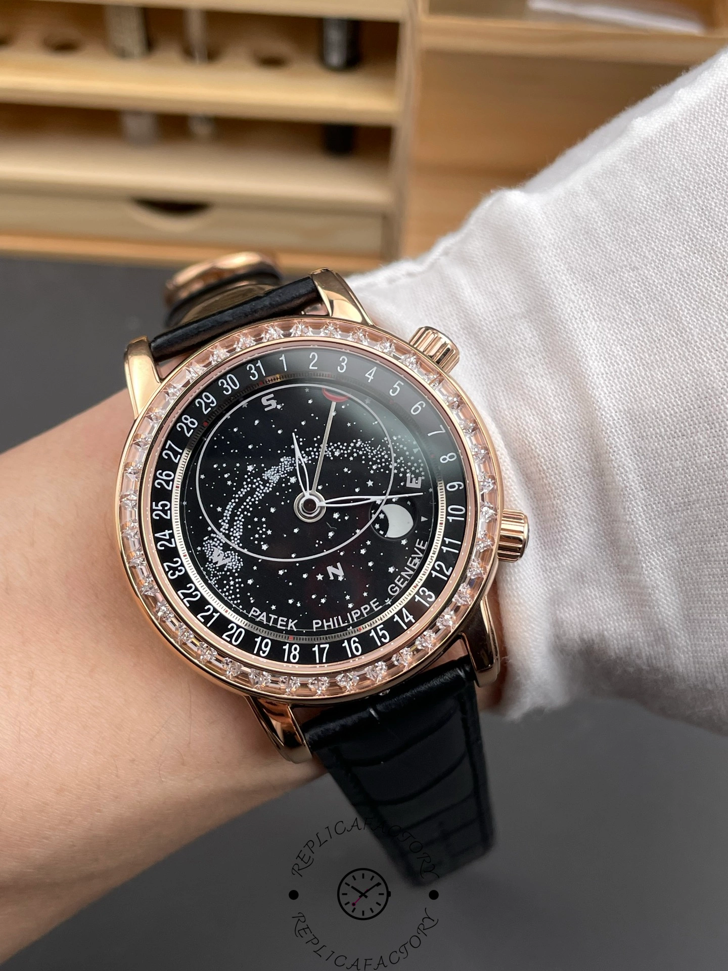 Wrist shot of Patek Philippe 6104R 001 showing celestial dial presence on black leather strap.