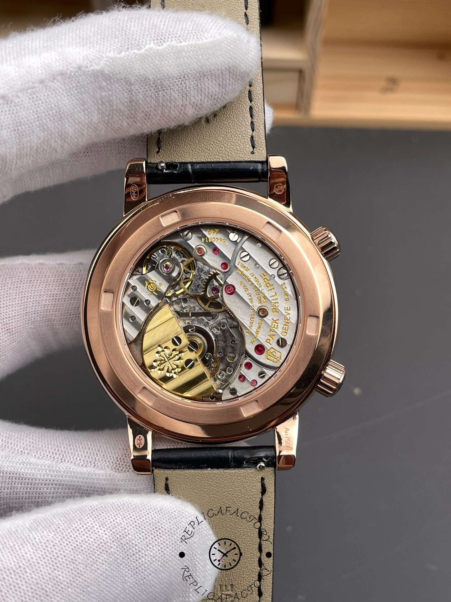 Caseback view of Patek Philippe 6104R 001 showing movement and engraved rotor through display back.