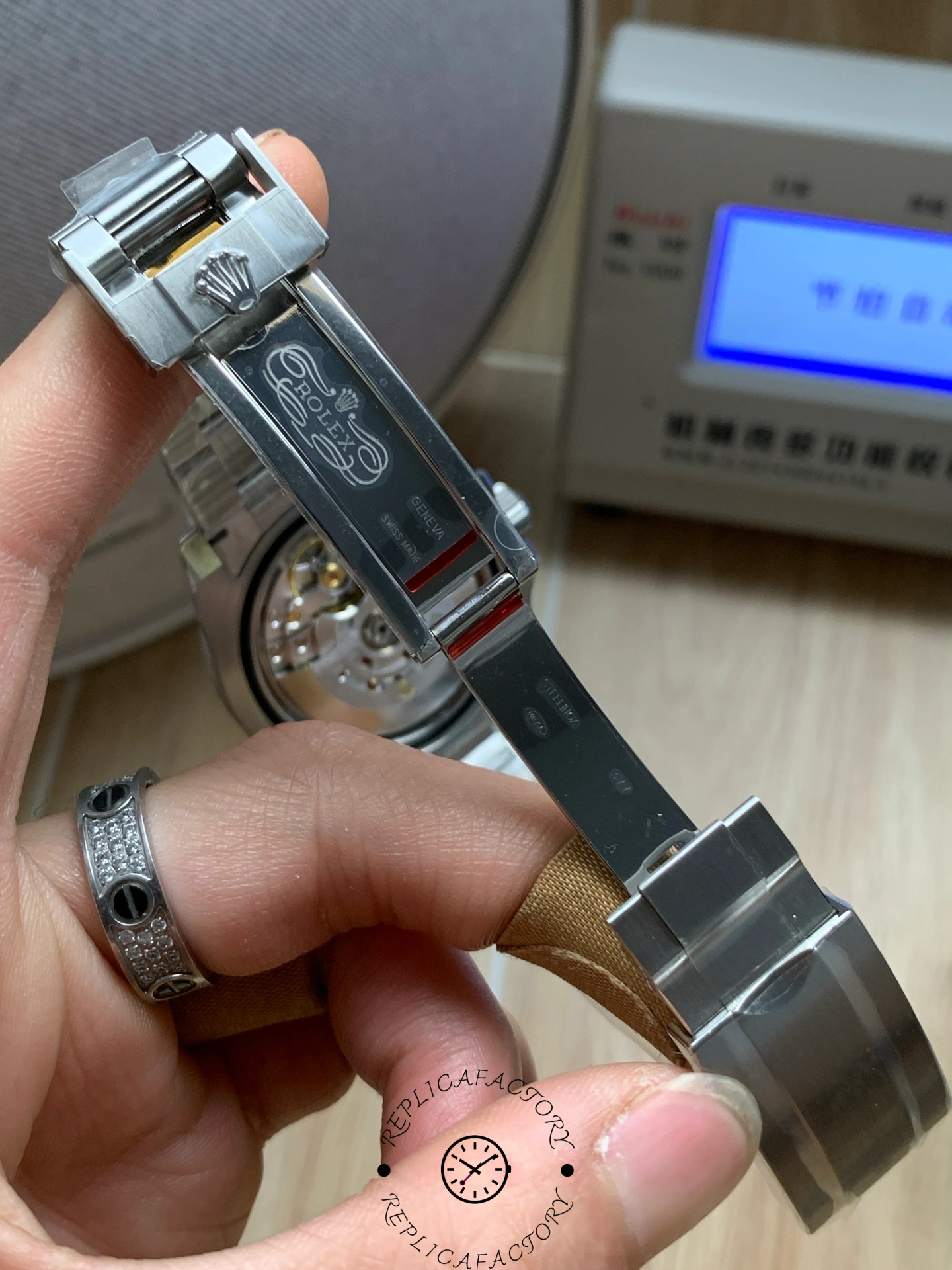 Rolex Submariner 126610LV, clasp detail in hand showing folding clasp and bracelet links.