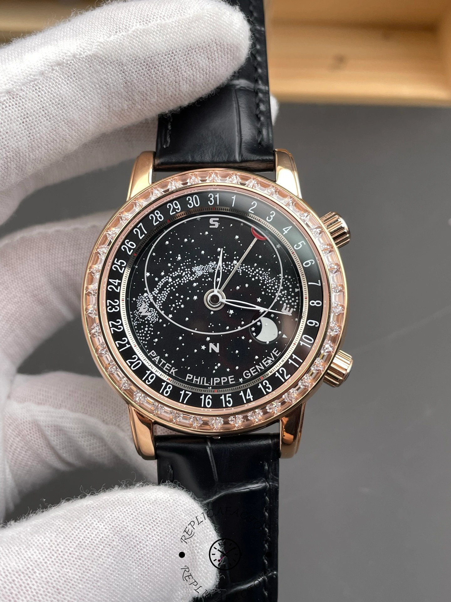 Angled front view of Patek Philippe 6104R 001 highlighting rose gold bezel and black strap.