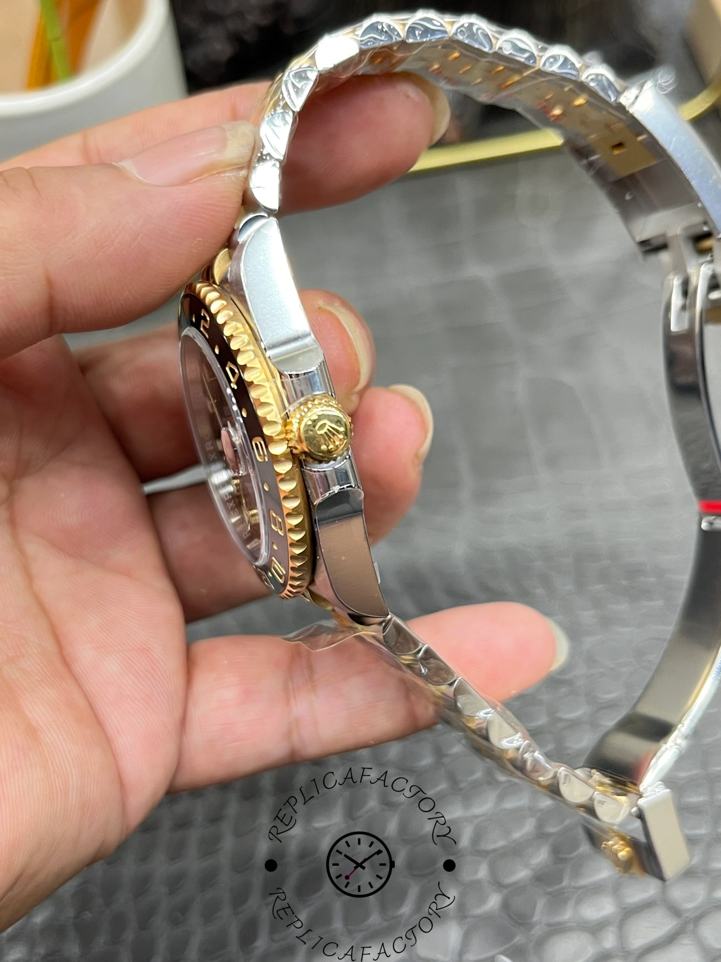 Side profile of Rolex GMT-Master II 126713GRNR 0001 showing crown and bracelet curve.