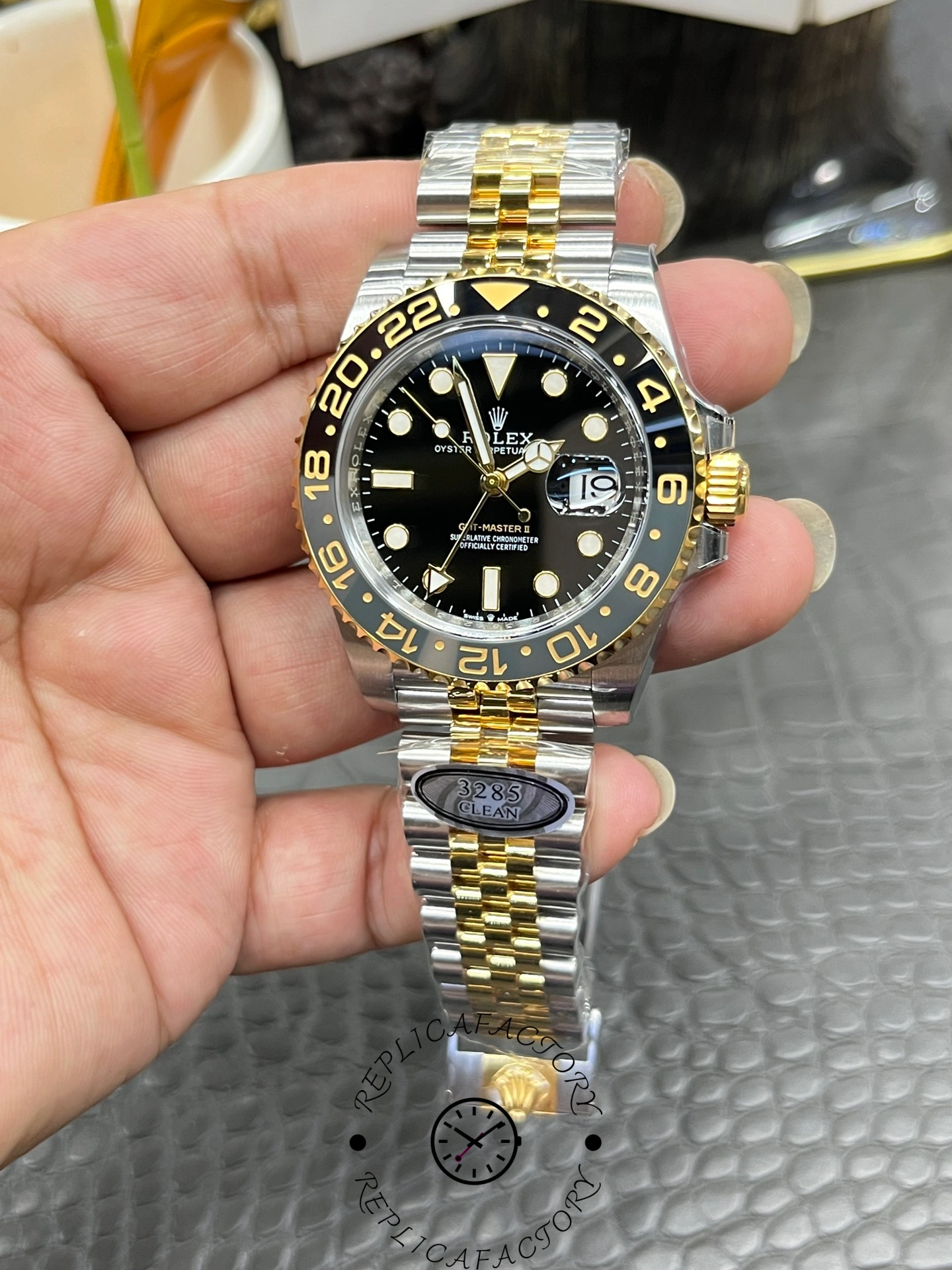 Handheld close-up of Rolex GMT-Master II 126713GRNR 0001, showing markers and date cyclops.