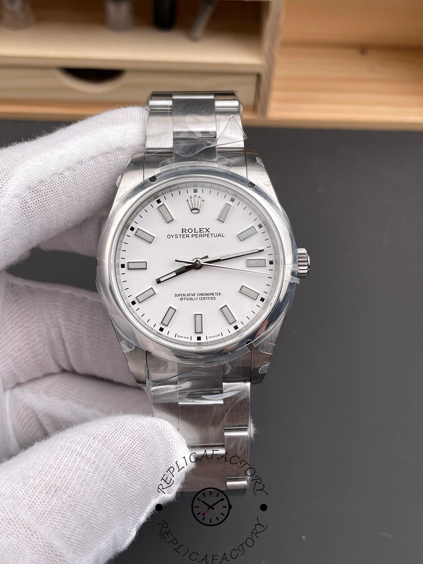 Rolex Oyster Perpetual 114300 hand shot, full watch face and bracelet visible.