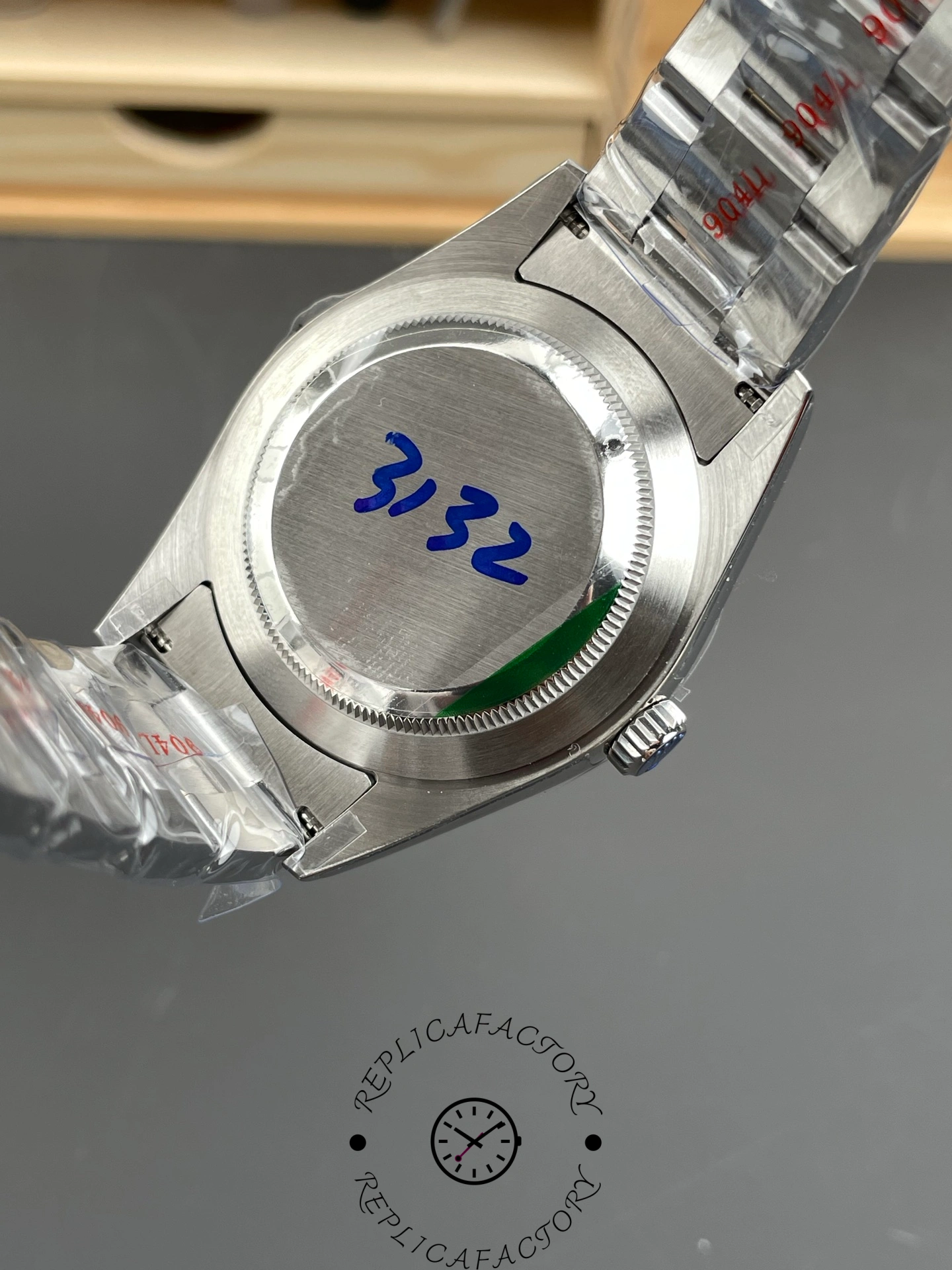 Rolex Oyster Perpetual 114300 case back view with protective stickers.