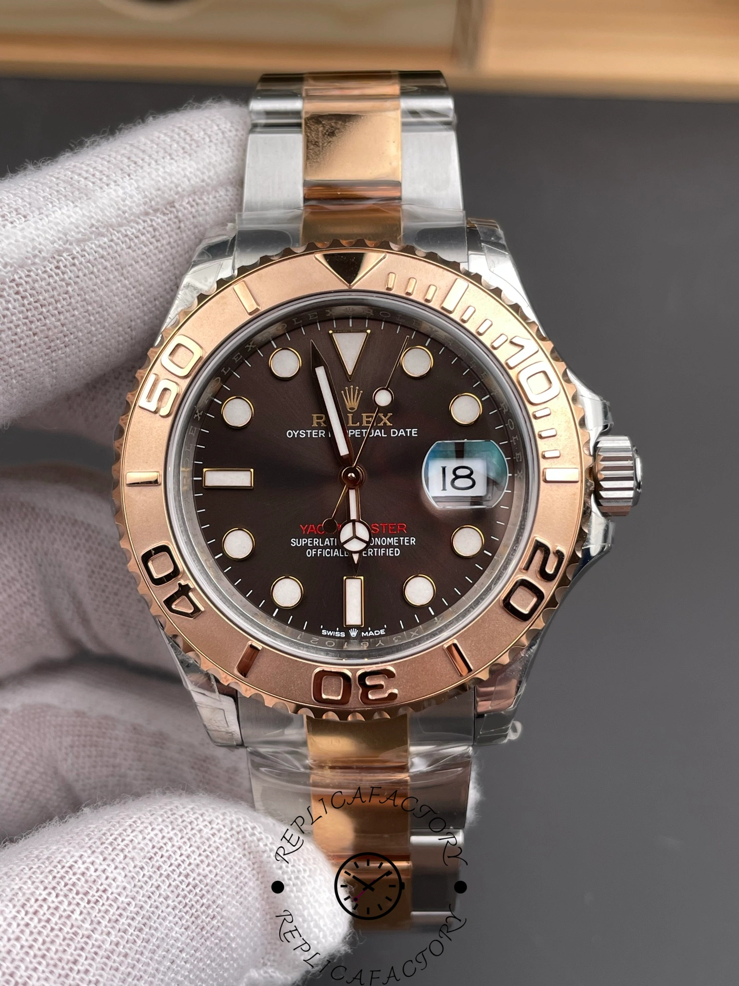 Rolex Yacht-Master 126621 close front view in glove, brown dial details and bezel numerals.