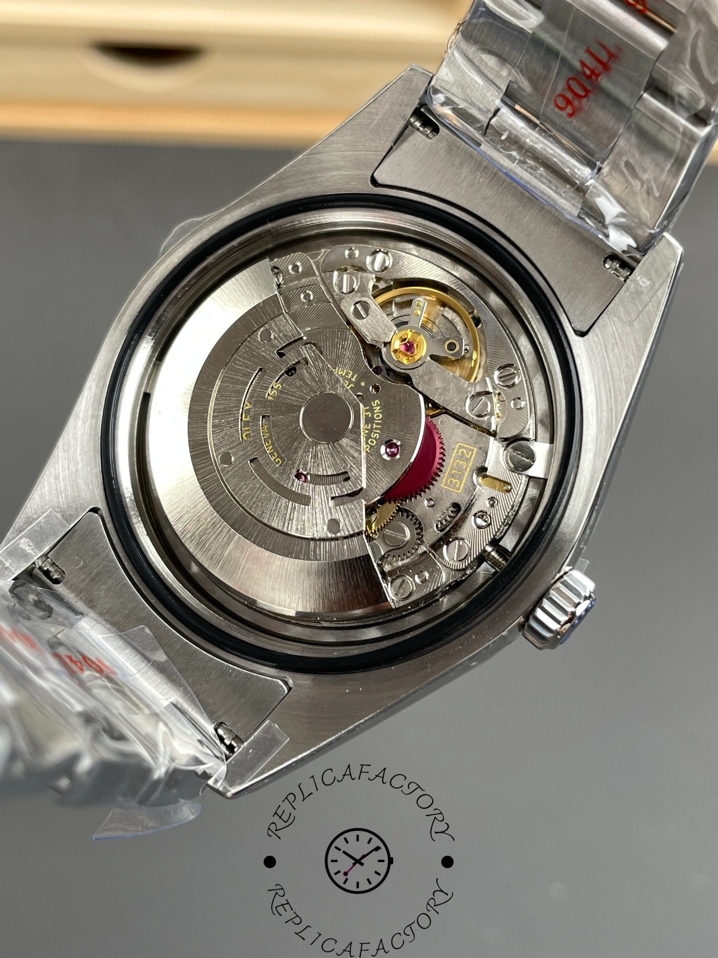 Rolex Oyster Perpetual 114300 open case back, automatic movement close-up.