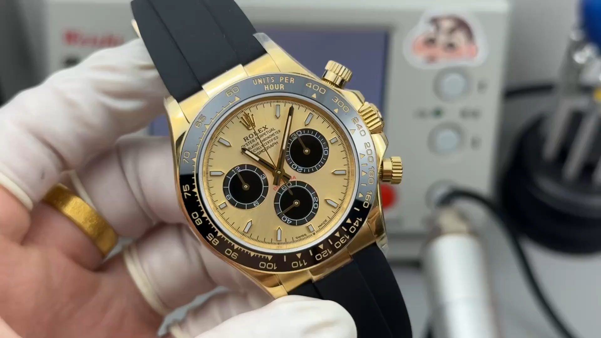 Video: hand holding Rolex Daytona 126518LN-0012, gold case and black strap visible. - Video