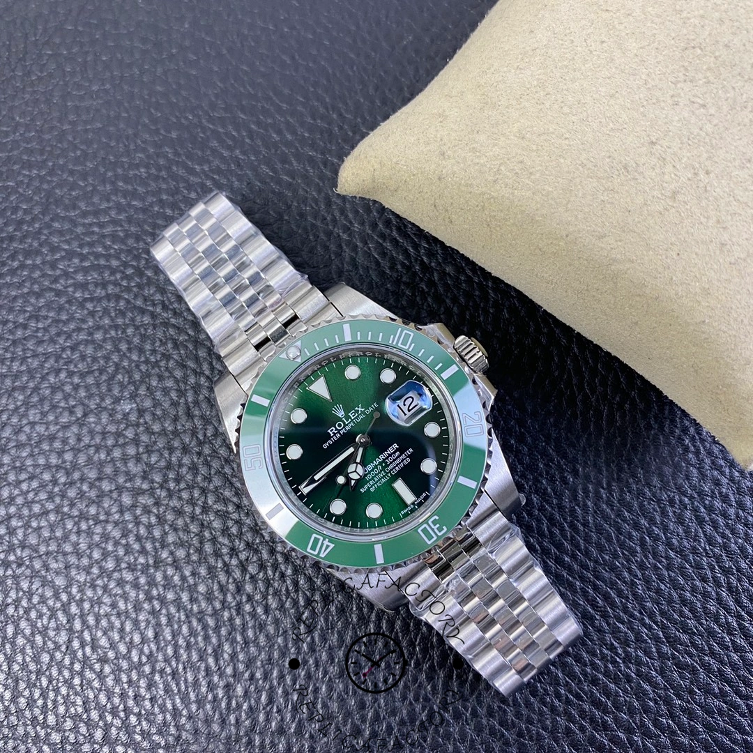 Full watch view of Rolex Submariner 116610LV with jubilee bracelet laid on cushion.