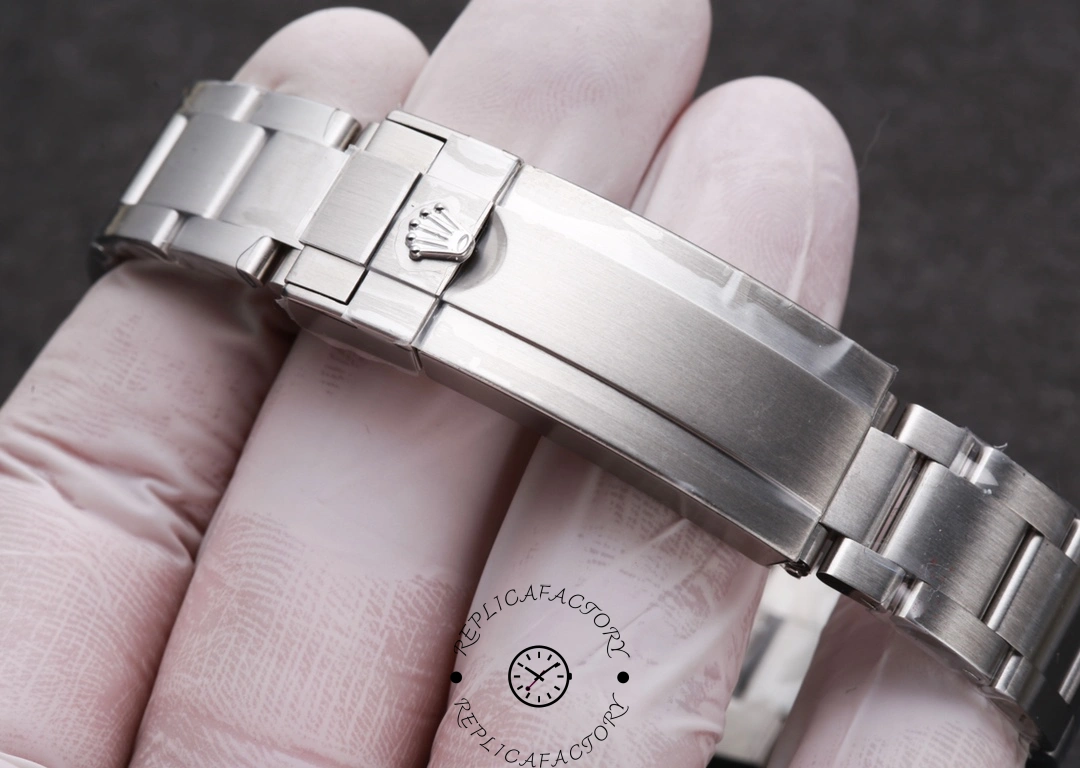 Rolex Submariner 126610LV, clasp close-up on glove showing polished clasp cover.