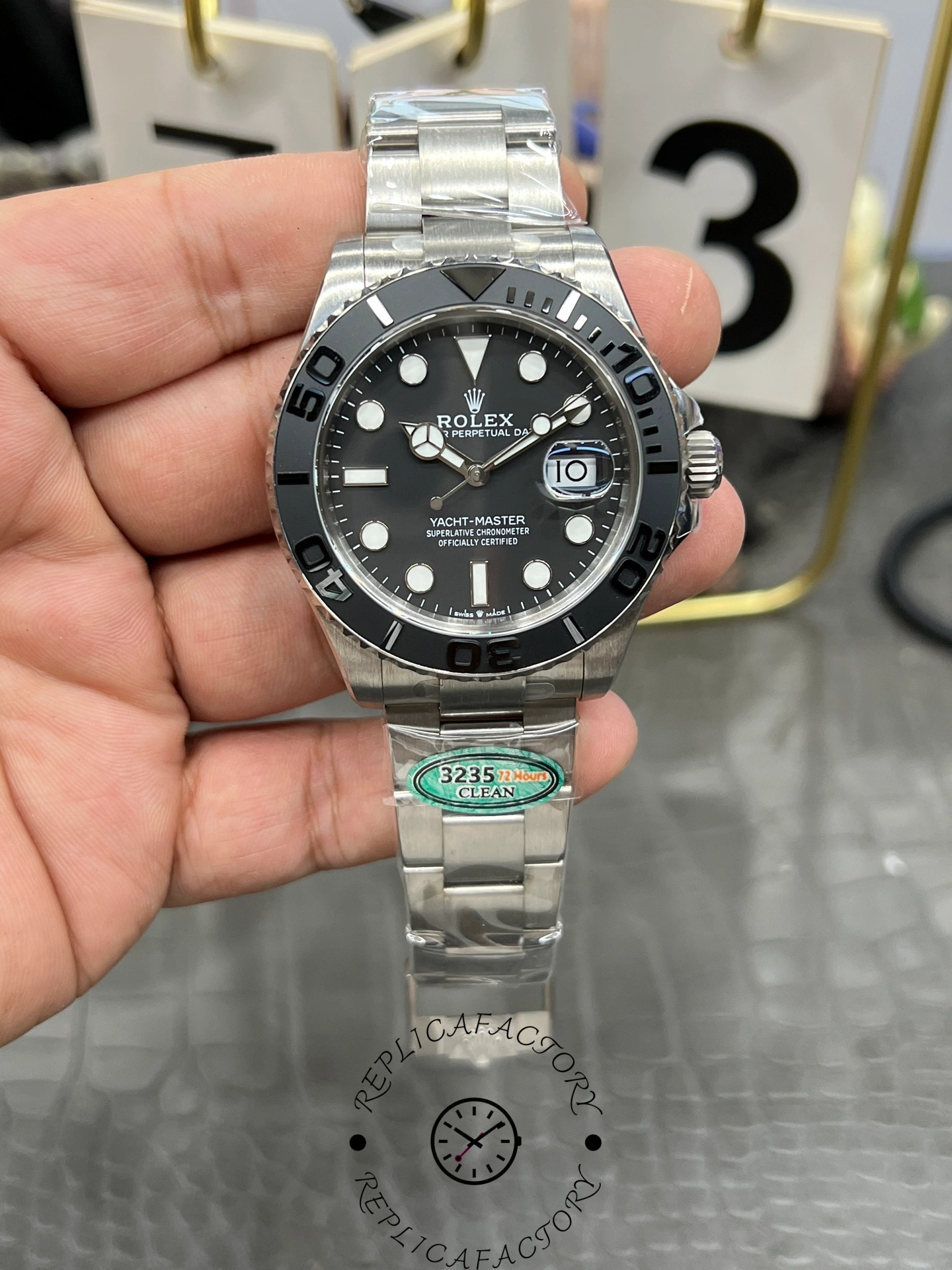 Rolex Yacht-Master 42 226627 0001, hand-held front view showing black dial and bezel.