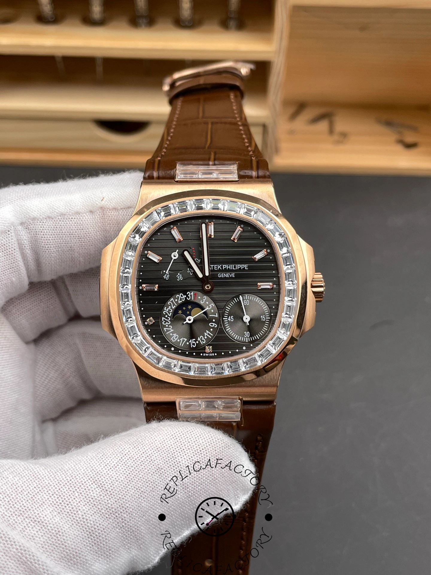 Hand-held front view of Patek Philippe Nautilus 5724-001 highlighting black dial layout and rose-gold bezel.
