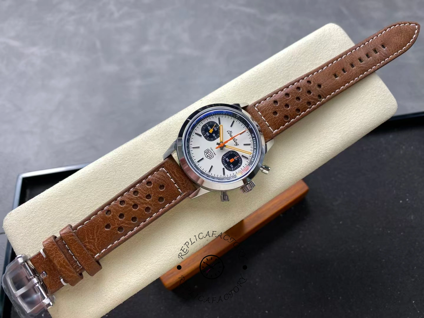 Breitling Top Time Deus A233101A1A1X1, full cushion view highlighting brown leather strap and stitching.