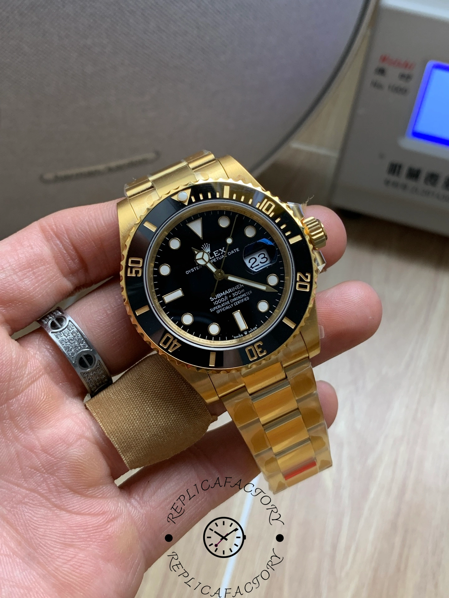 Rolex Submariner 126618LN, angled front view in hand, gold bracelet visible.