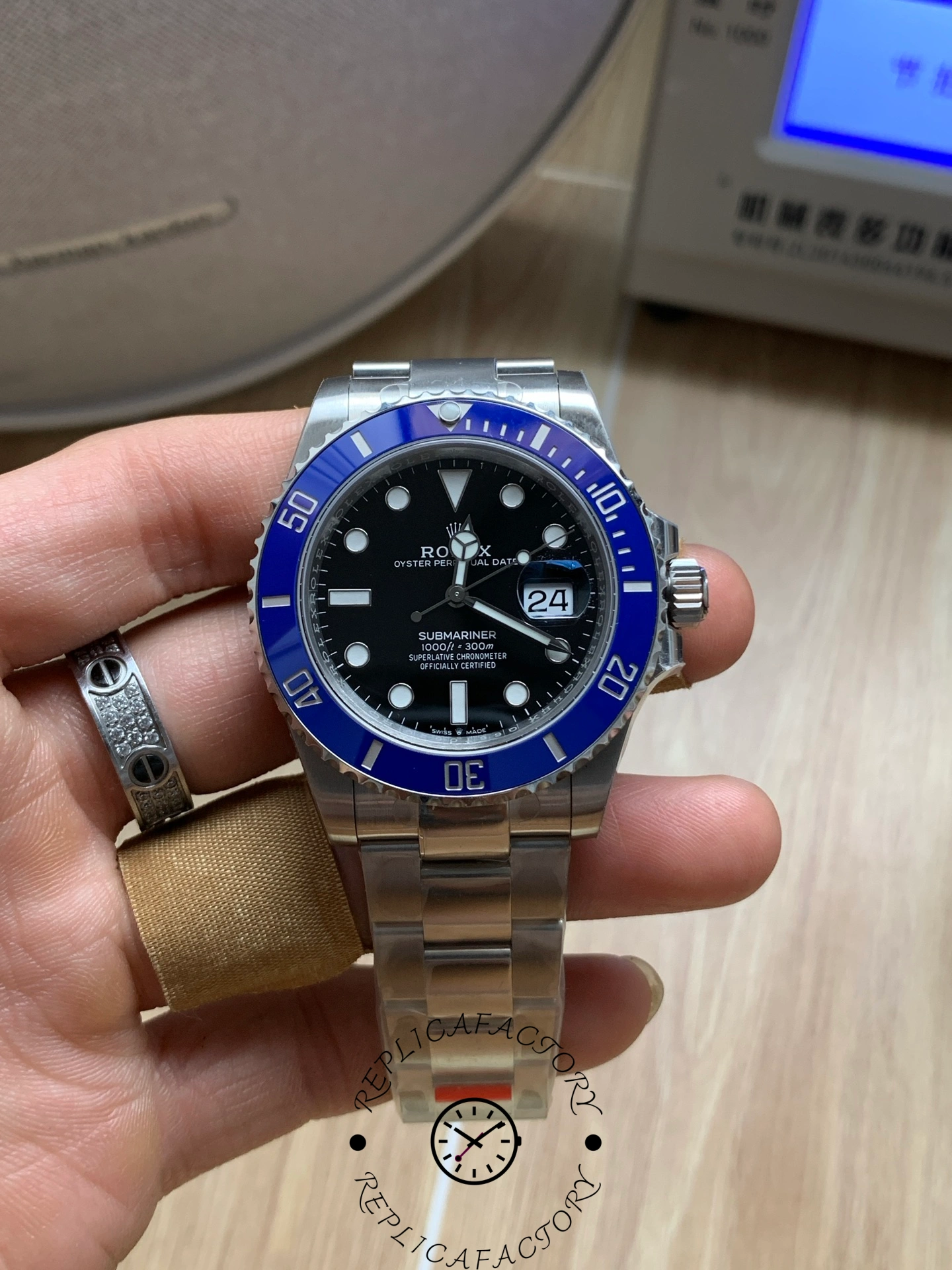 Rolex Submariner 126619LB 0003, hand-held front view under indoor light.