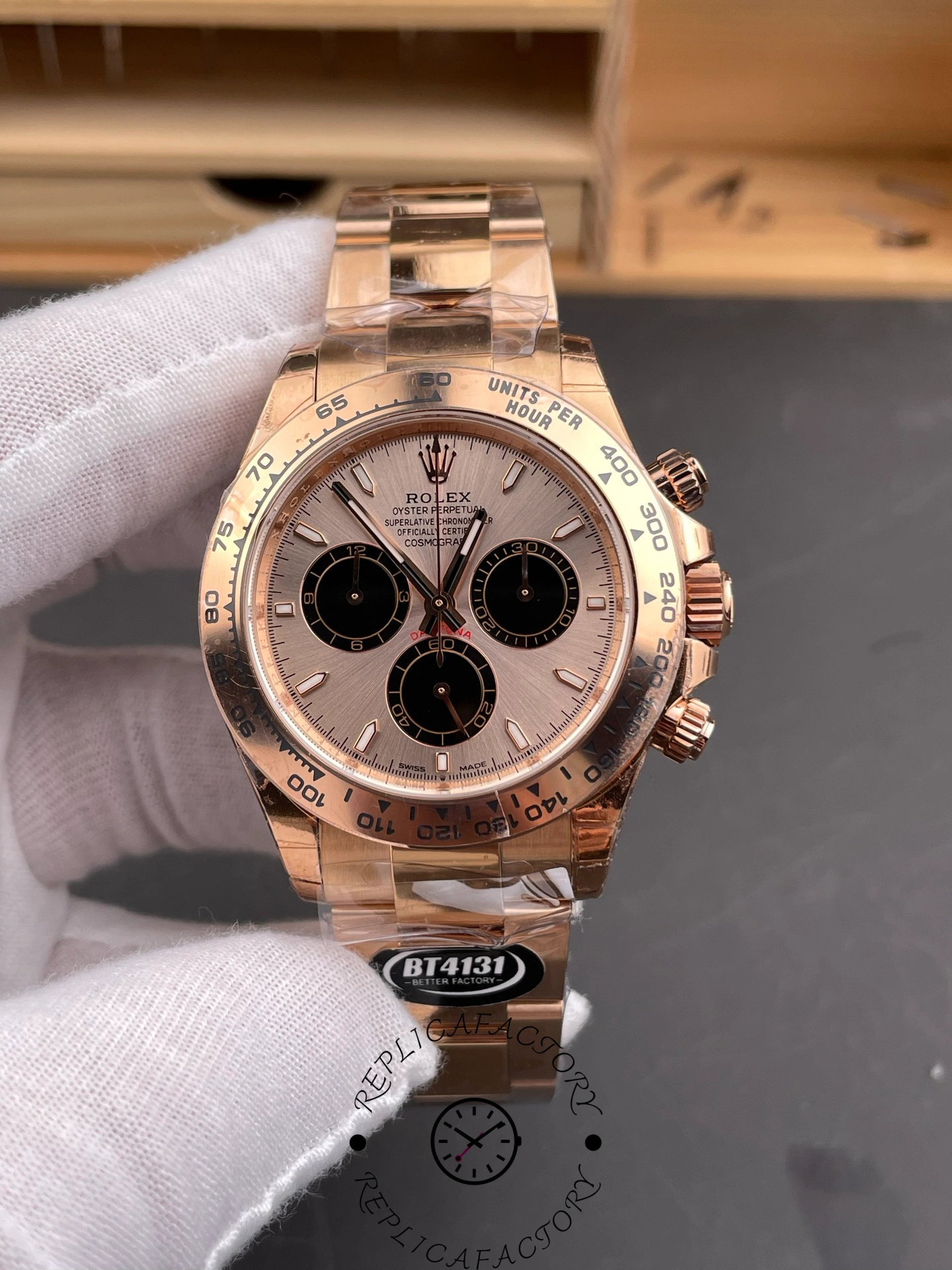 Gloved front view of the Rolex Daytona 126505 showing sundust dial and contrasting black subdials.