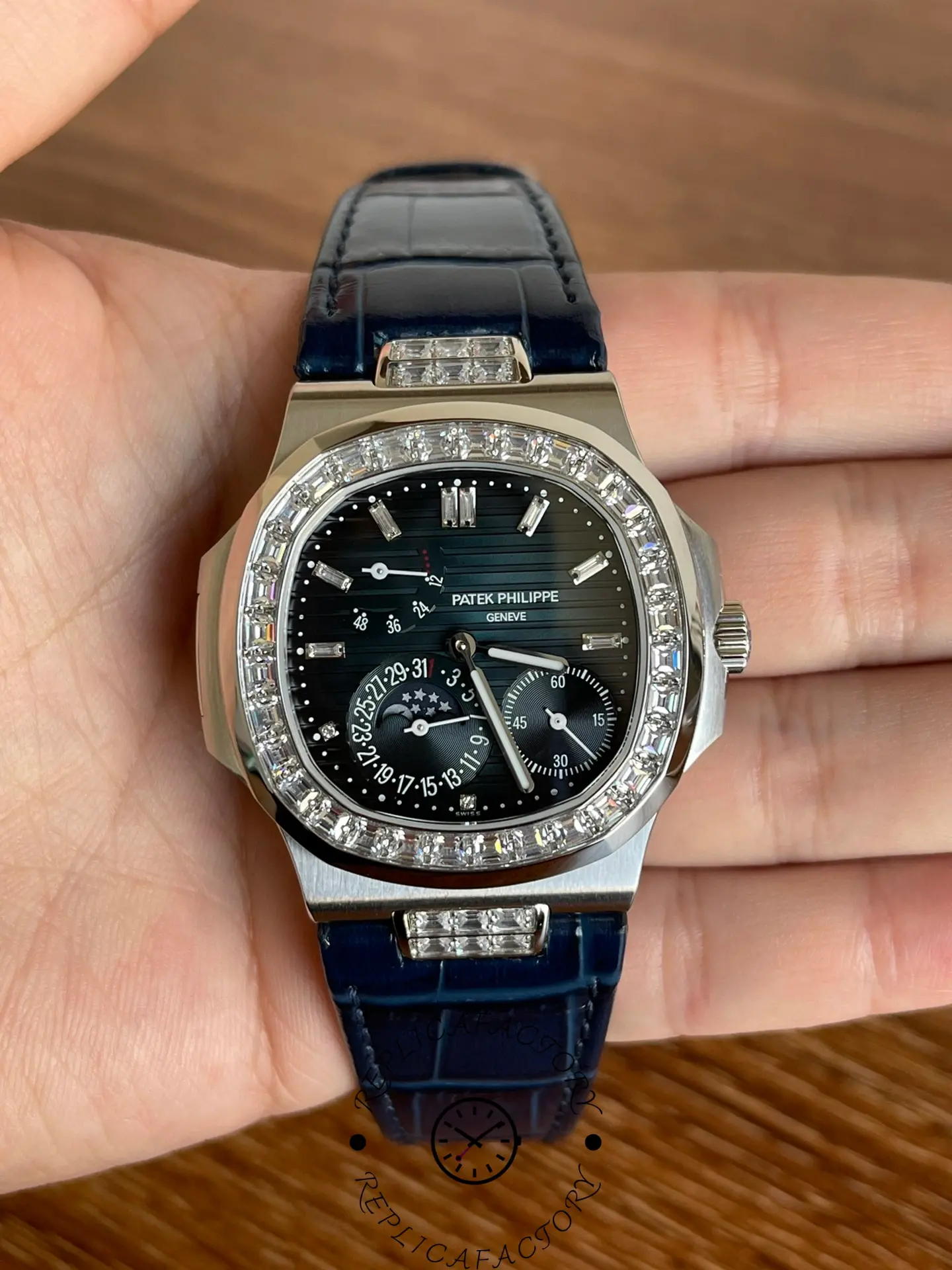 Hand-held front view of Patek Philippe Nautilus 5724G-001 showing black dial and luminous markers.