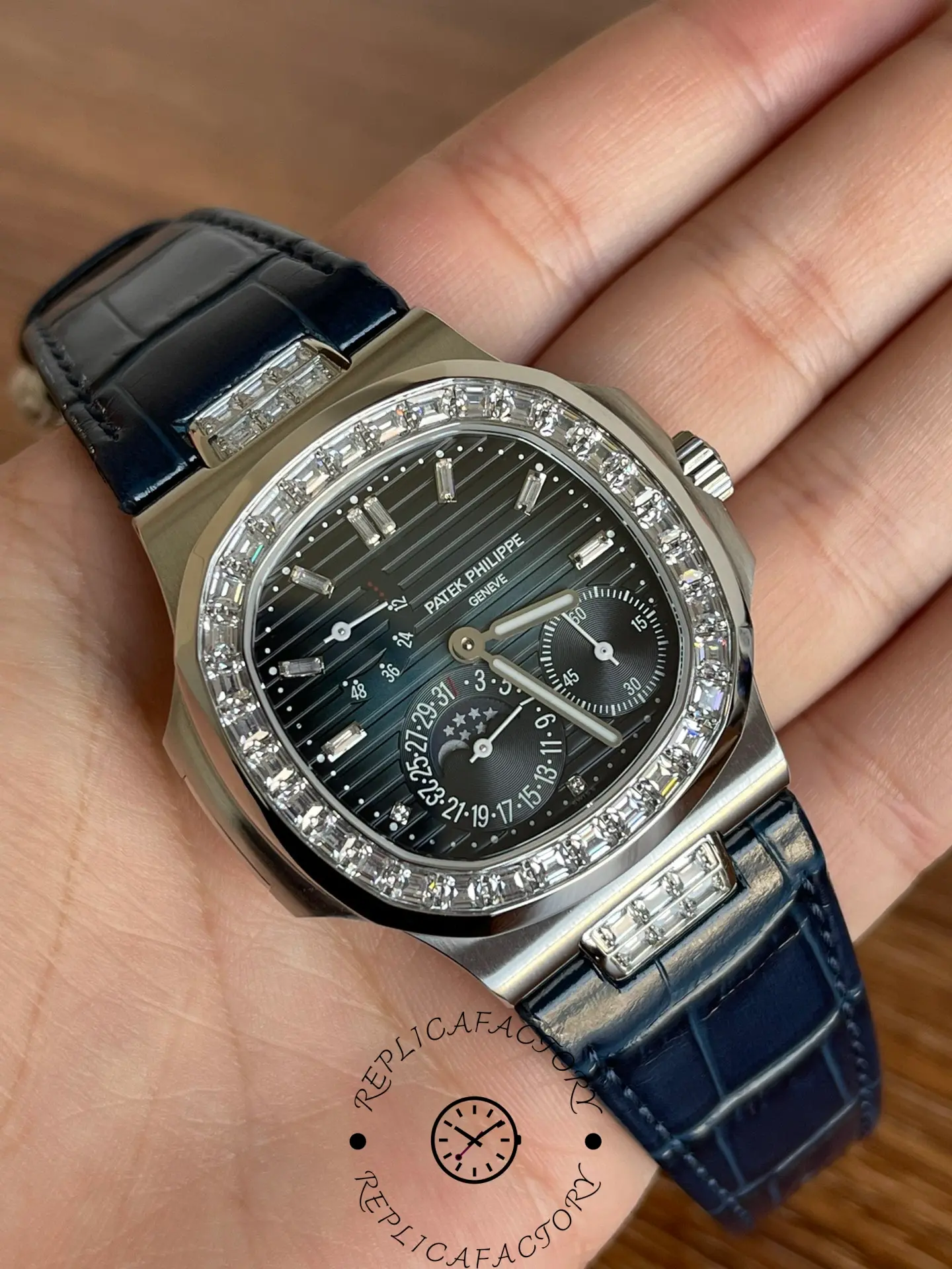 Palm shot of Patek Philippe Nautilus 5724G-001 showing black dial and blue strap from above.