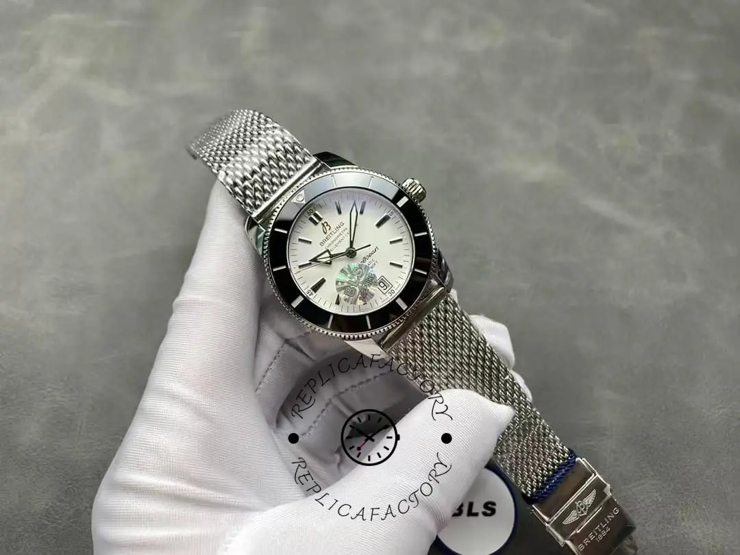 Hand-held view of Breitling Superocean Heritage II AB201012/G827-154A showing dial and mesh bracelet.