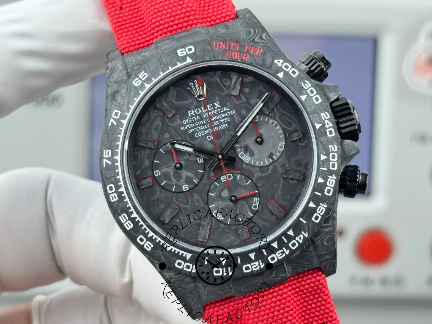 Rolex DIW Daytona NTPT Carbon 40mm, straight-on close view with the red strap running behind the case.