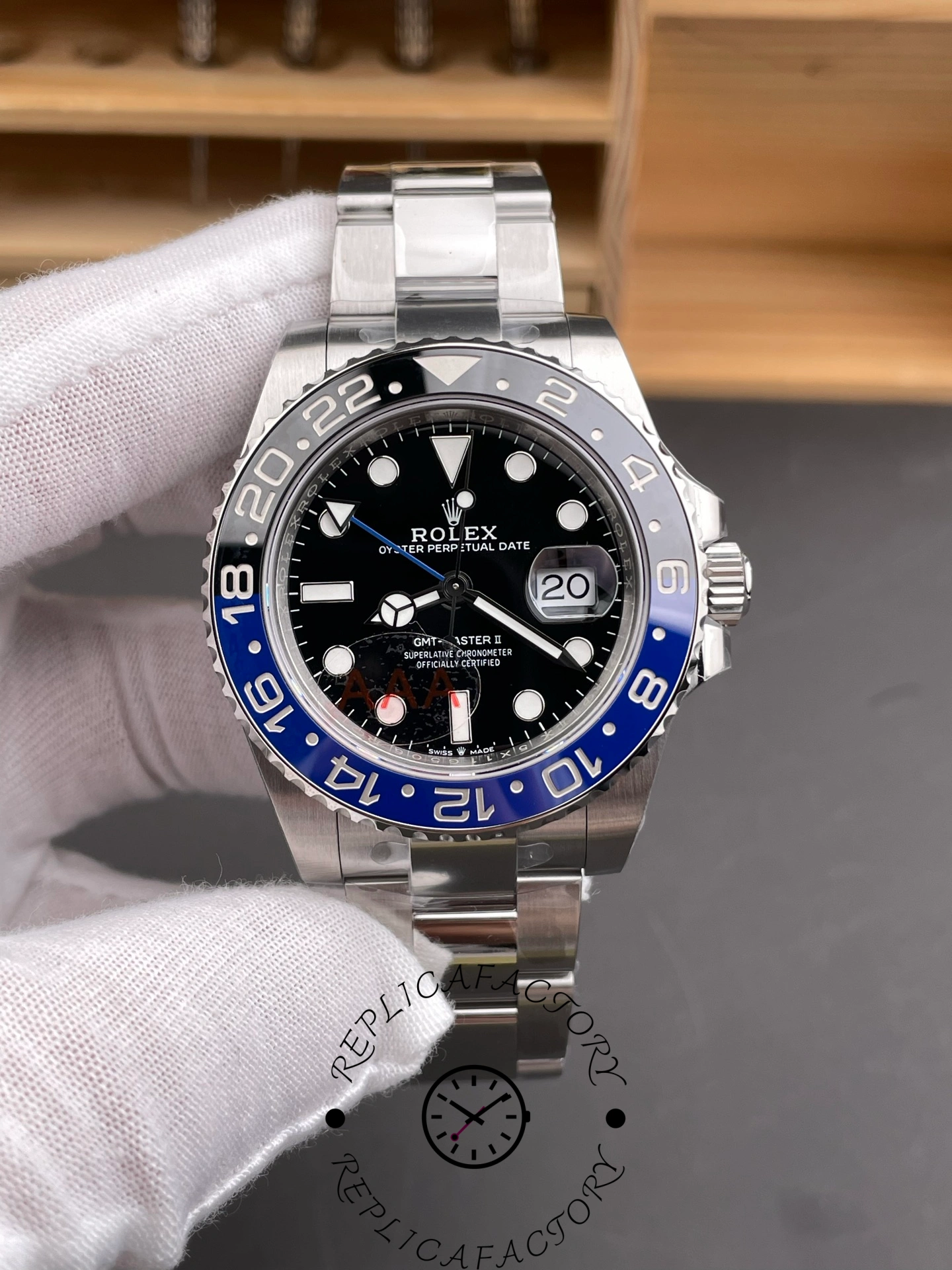 Rolex GMT-Master II 126710BLNR 0003 held in glove, black dial and blue-black bezel, front view.