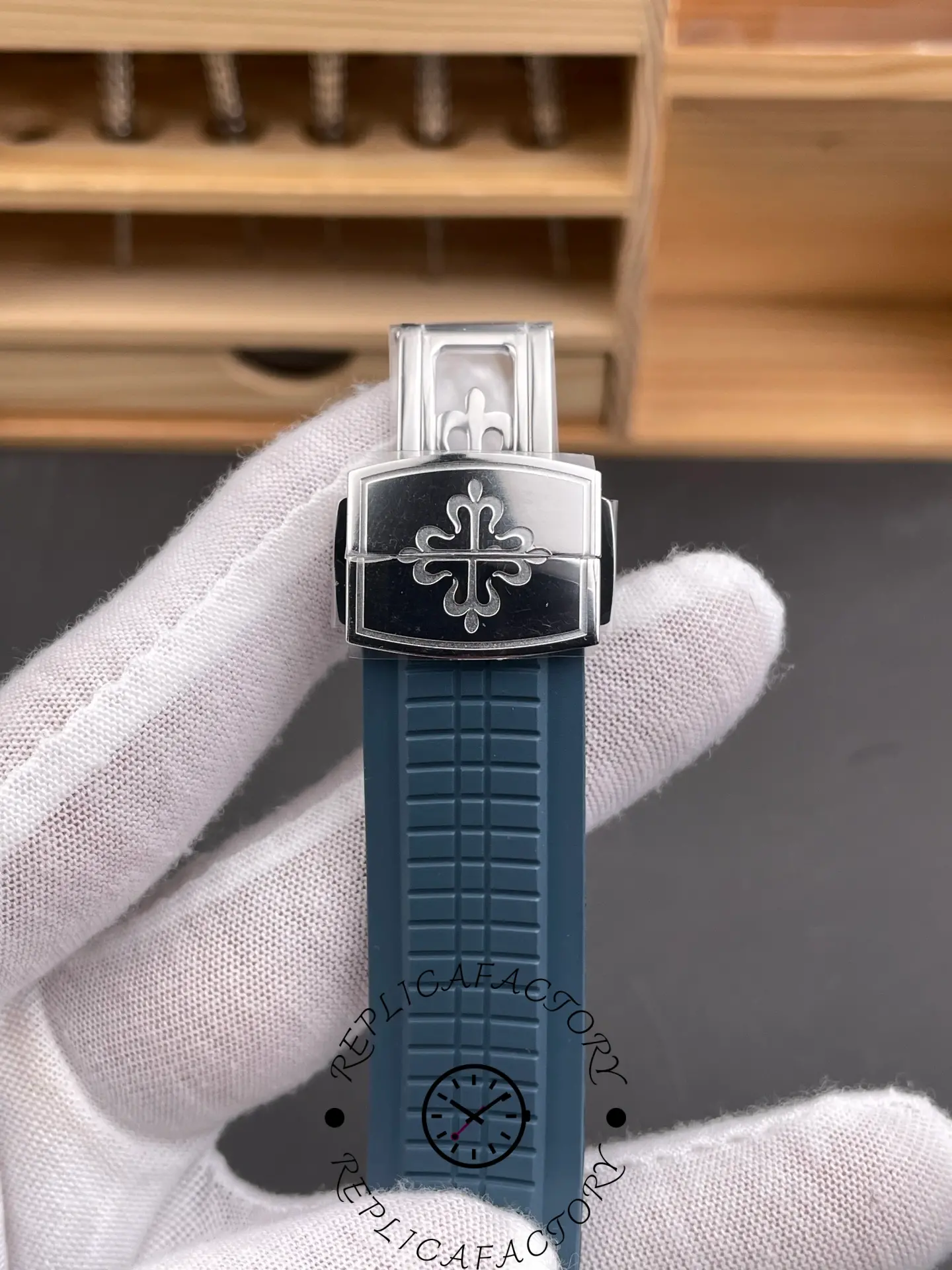 Close-up clasp view of Patek Philippe Aquanaut 5164G-001 showing engraved clasp and blue strap.