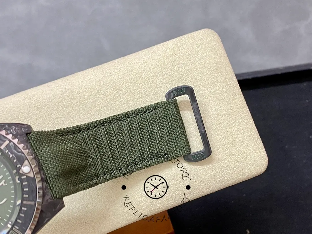 Rolex Sea-Dweller DiW Carbon HUNTER ARABIC buckle close-up, green fabric strap and metal keeper.