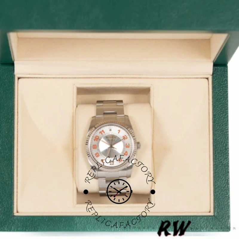 Rolex Air-King 114200 displayed in watch box, concentric silver dial with orange accents, front view.