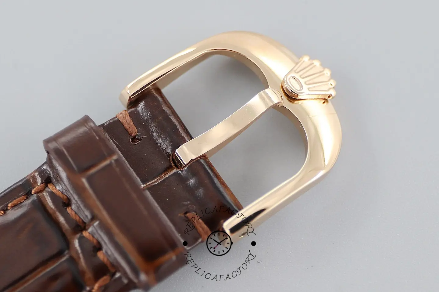 Rolex Cellini Date 50515 buckle close-up, rose gold tone pin buckle on brown crocodile strap.