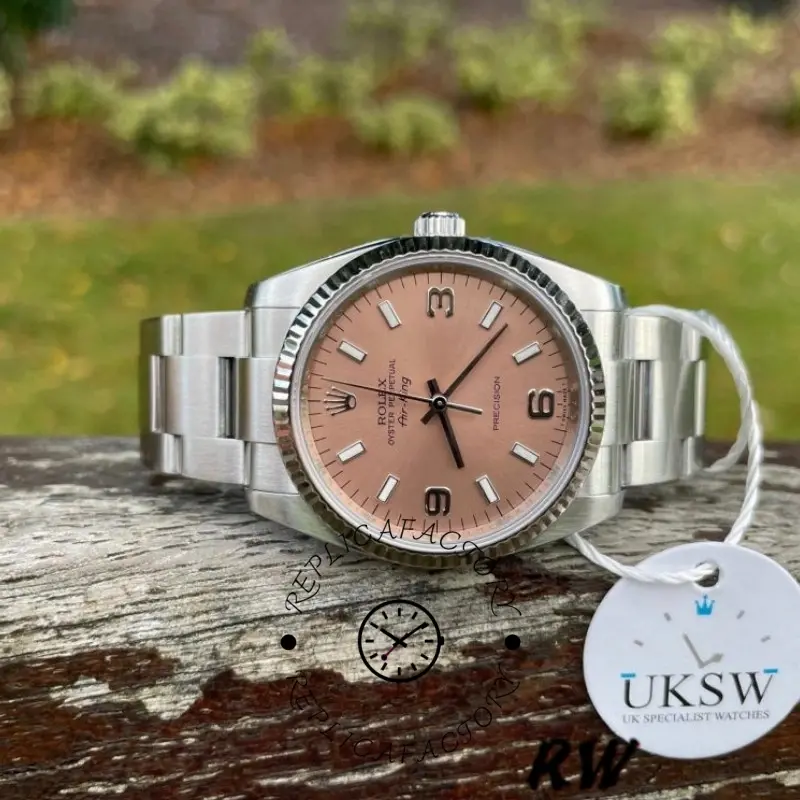 Rolex Oyster Perpetual Air-King 114234, pink dial 34mm, side view on log background.