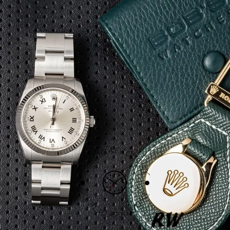 Rolex Air-King 114234 on fabric with Rolex tag, silver Roman diamond dial, top view.