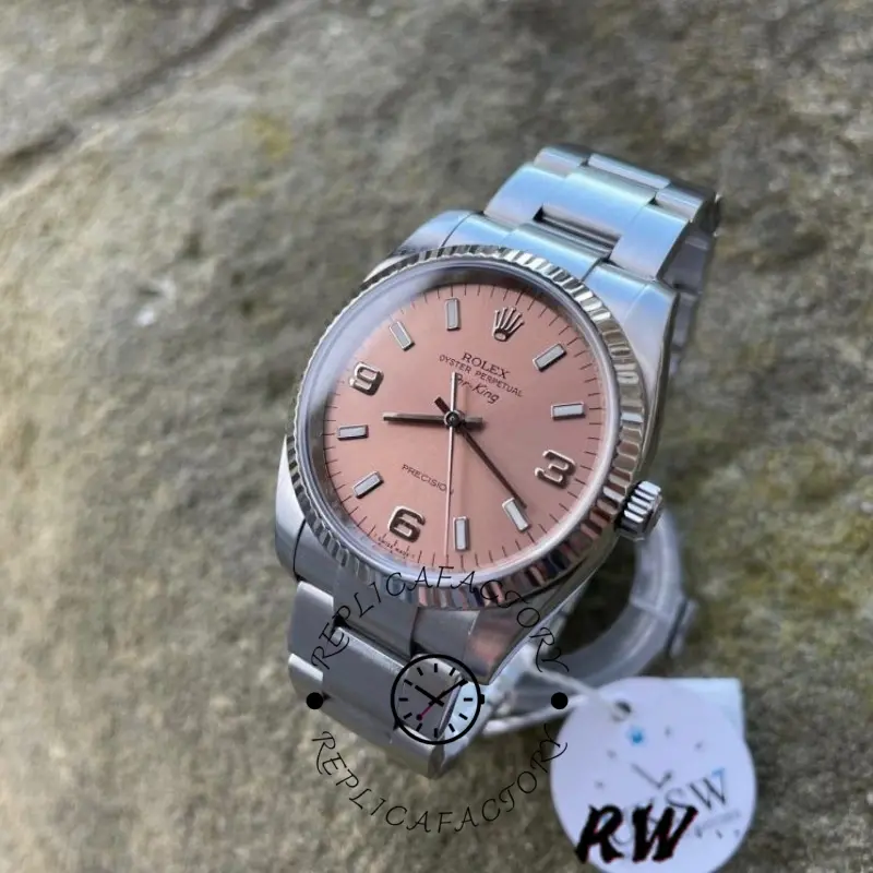 Rolex Oyster Perpetual Air-King 114234, pink dial 34mm, three-quarter view on stone.