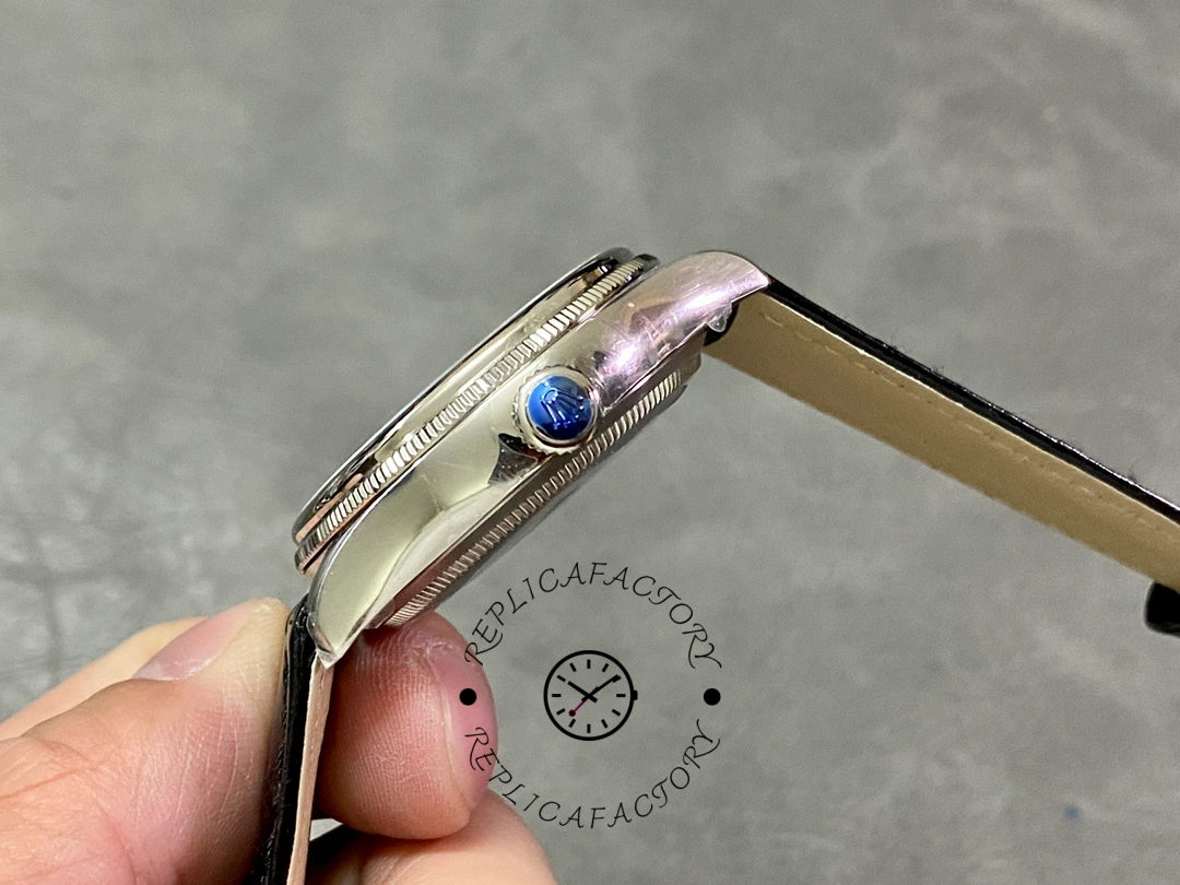 Rolex Cellini Dual Time 50529, crown-side close-up showing case profile and blue cabochon crown.