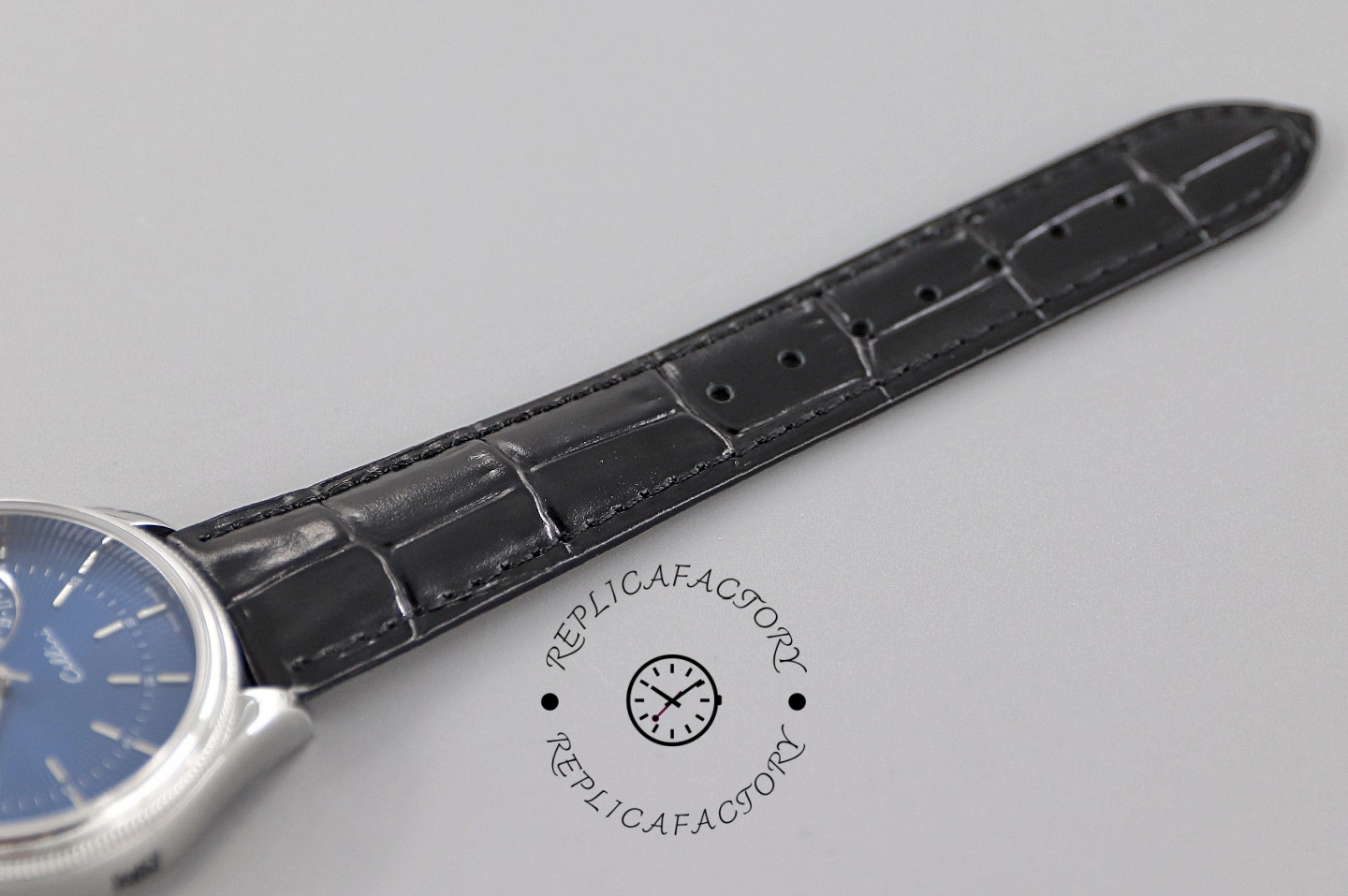 Rolex Cellini Date 50519 strap laid out on gray, blue leather strap and keeper, top view.