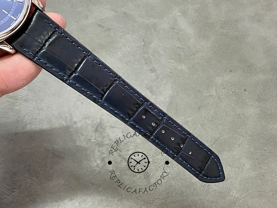 Rolex Cellini Date 50519 strap laid out, blue leather strap length and stitching, top view.