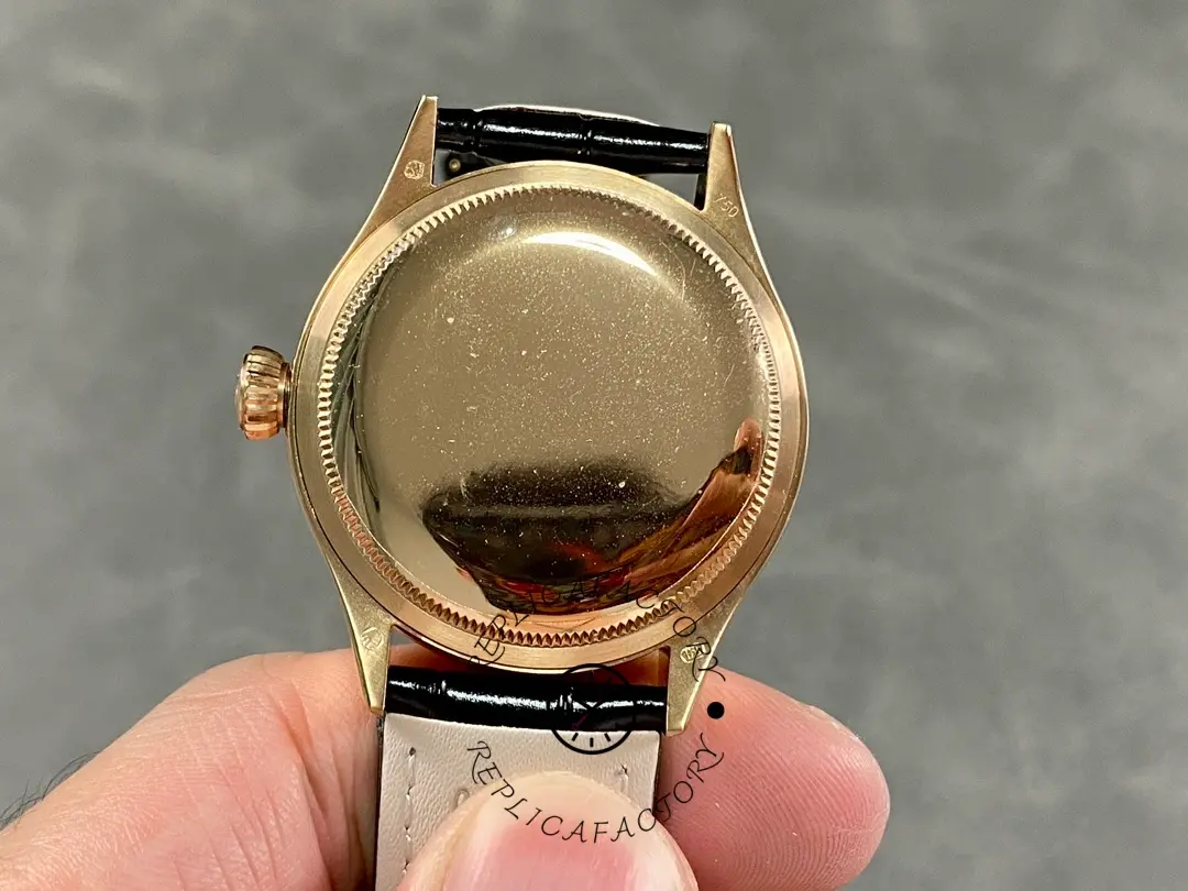 Rolex Cellini Dual Time 50525 case back view, smooth rose gold back, black leather strap attached.