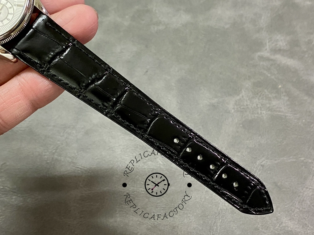 Rolex Cellini Dual Time 50529, black leather strap laid flat showing stitching and grain pattern.