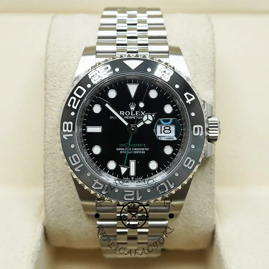 Rolex GMT-Master II M126710GRNR 0003, front display on pillow with black dial and bezel.