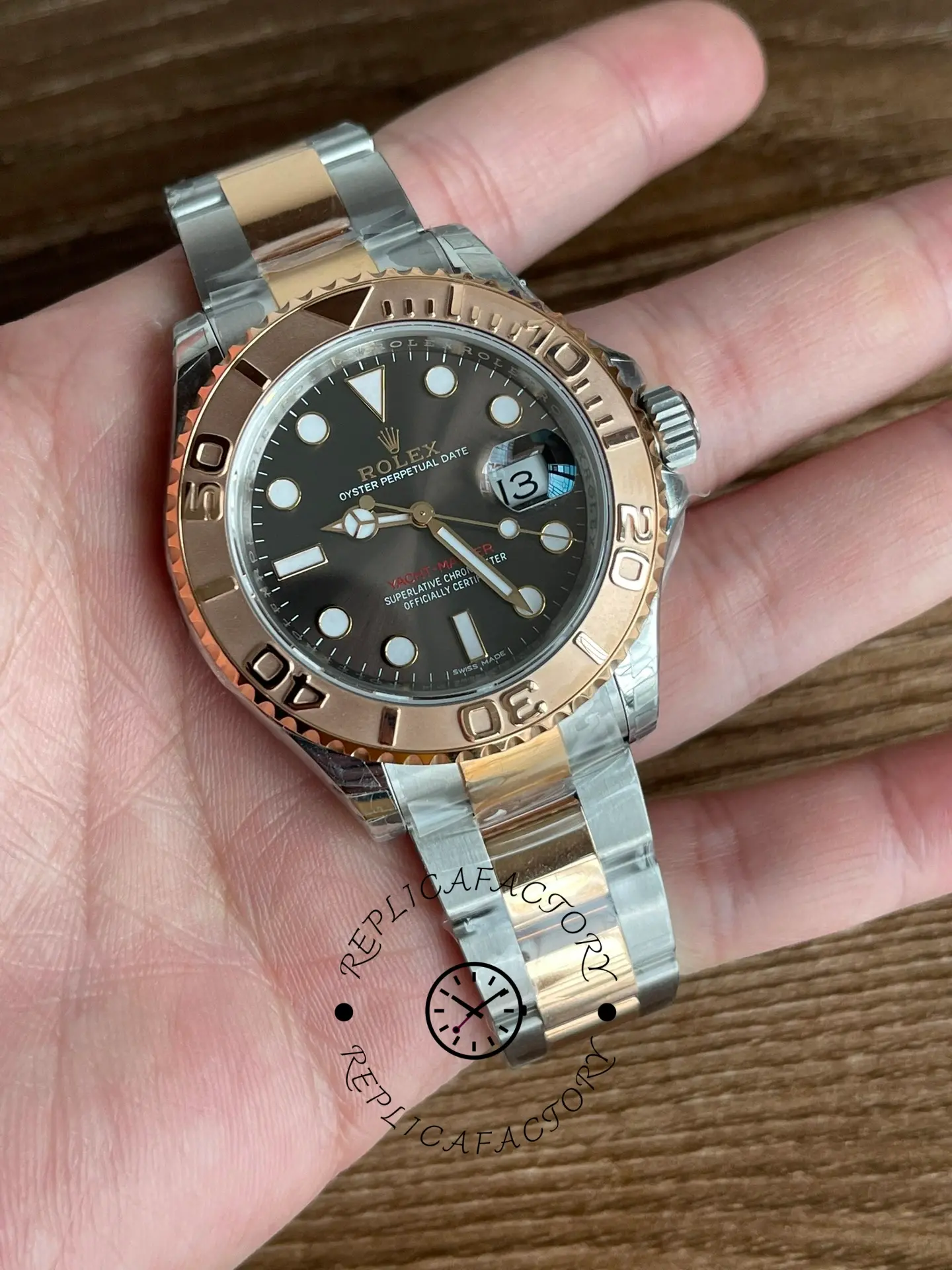 Rolex Yacht-Master 126621 held in hand, angled front view, black dial and Everose bezel.