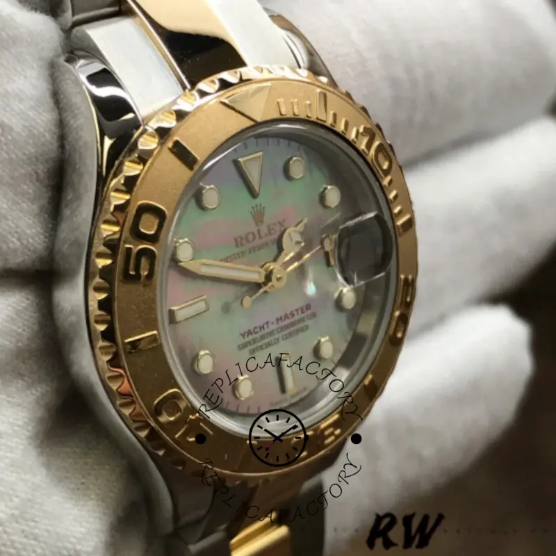 Rolex Yacht-Master 169623 angled view, black MOP dial shimmer and gold bezel, in glove.